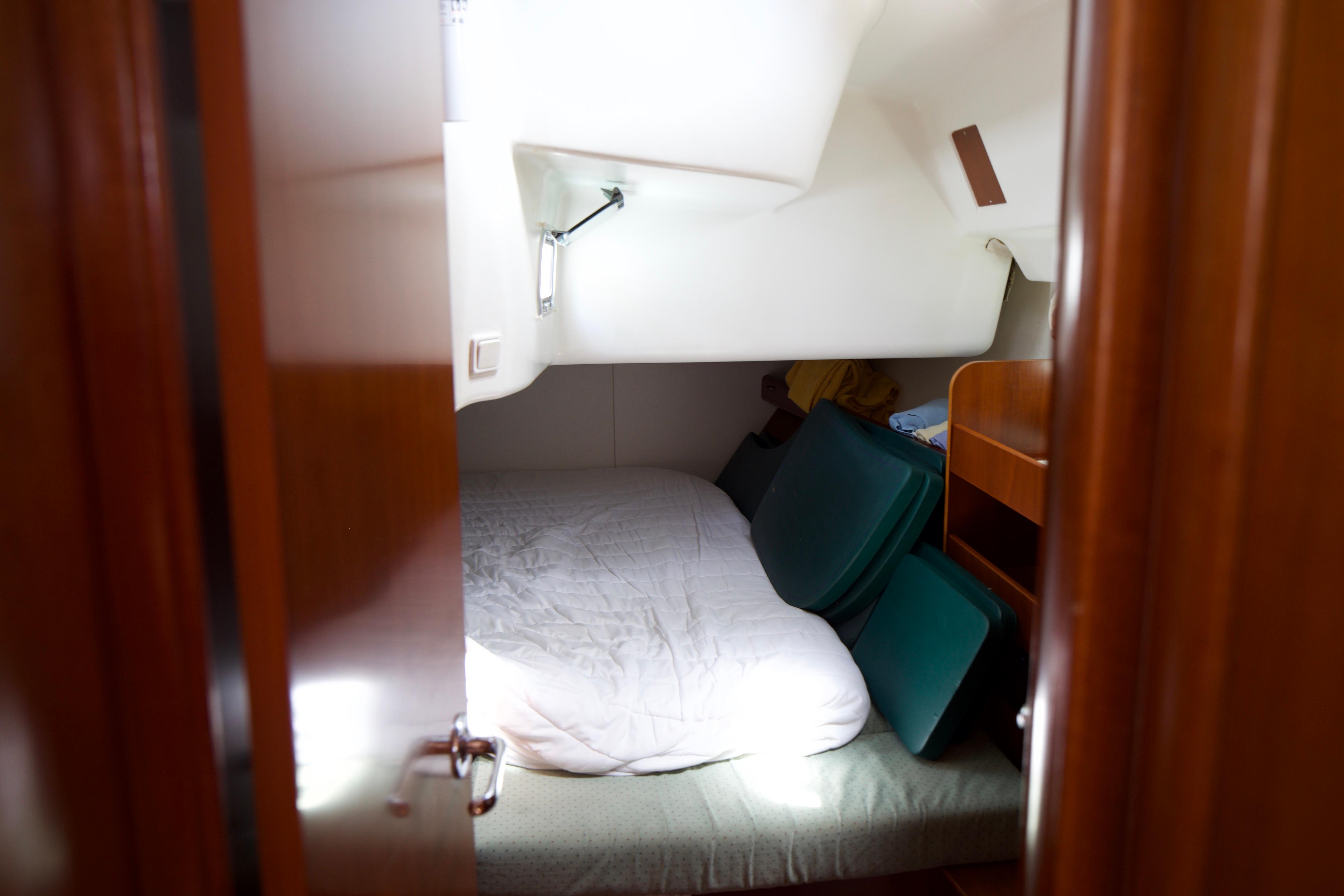 Cozy cabin interior of 2005 Beneteau 423 sailboat with bed and storage.
