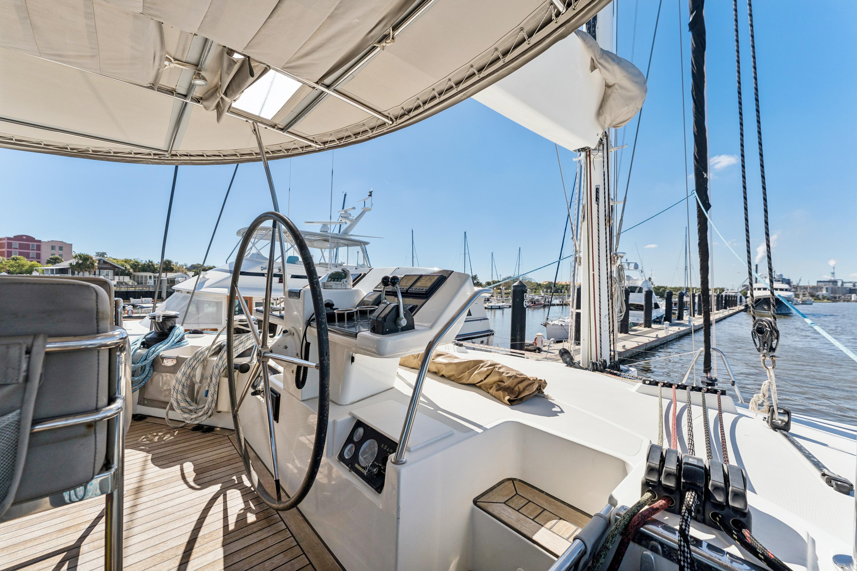 Luxurious 2012 Lagoon 560 catamaran docked at marina, featuring spacious helm and modern design.