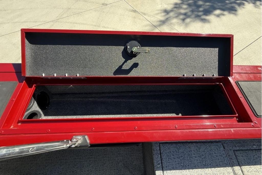 Open storage compartment on 2024 Tracker Targa V-19 WT boat, featuring red trim.