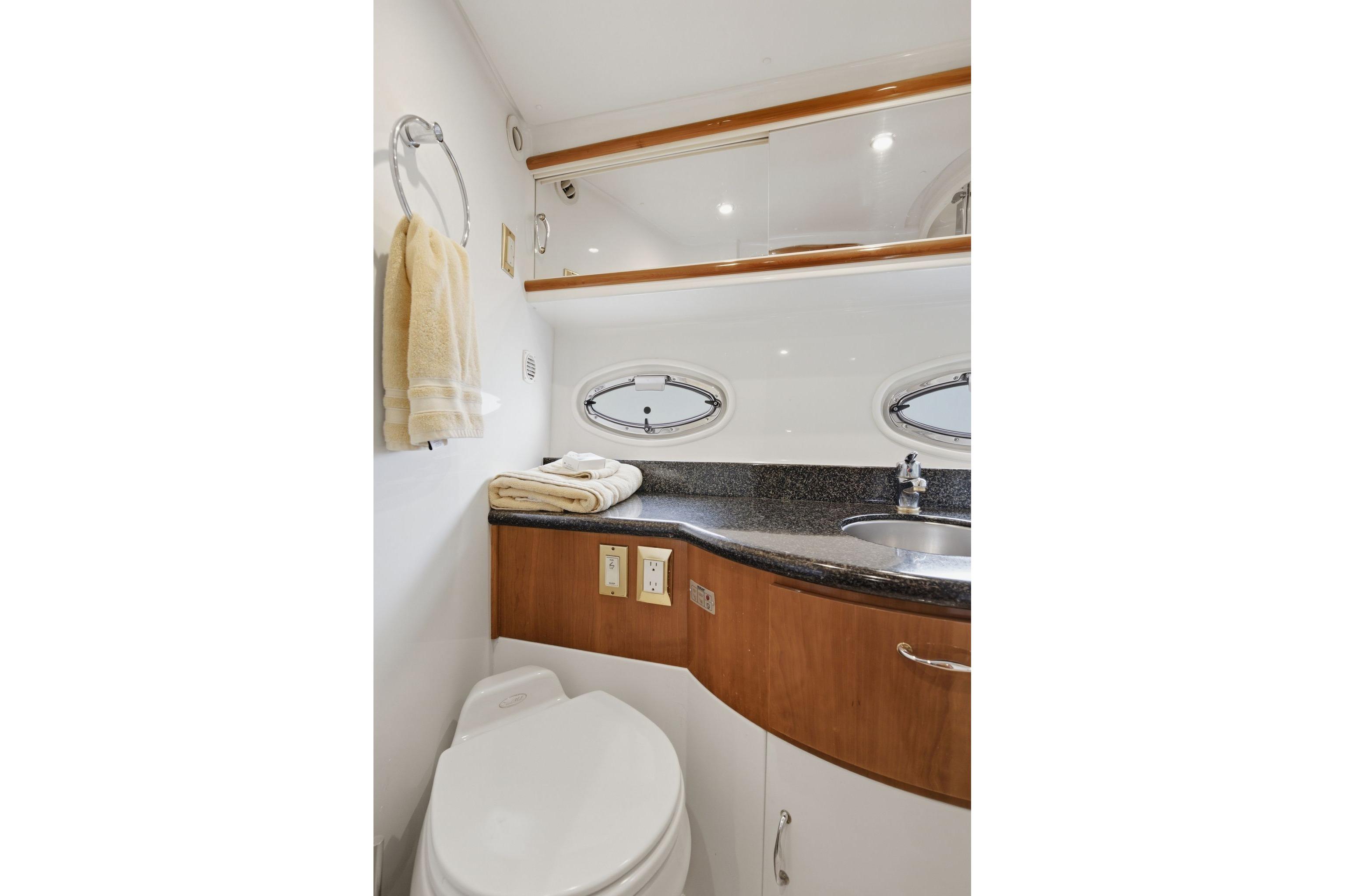 Bathroom interior of 2005 Carver 39 Motor Yacht with sink and porthole windows.