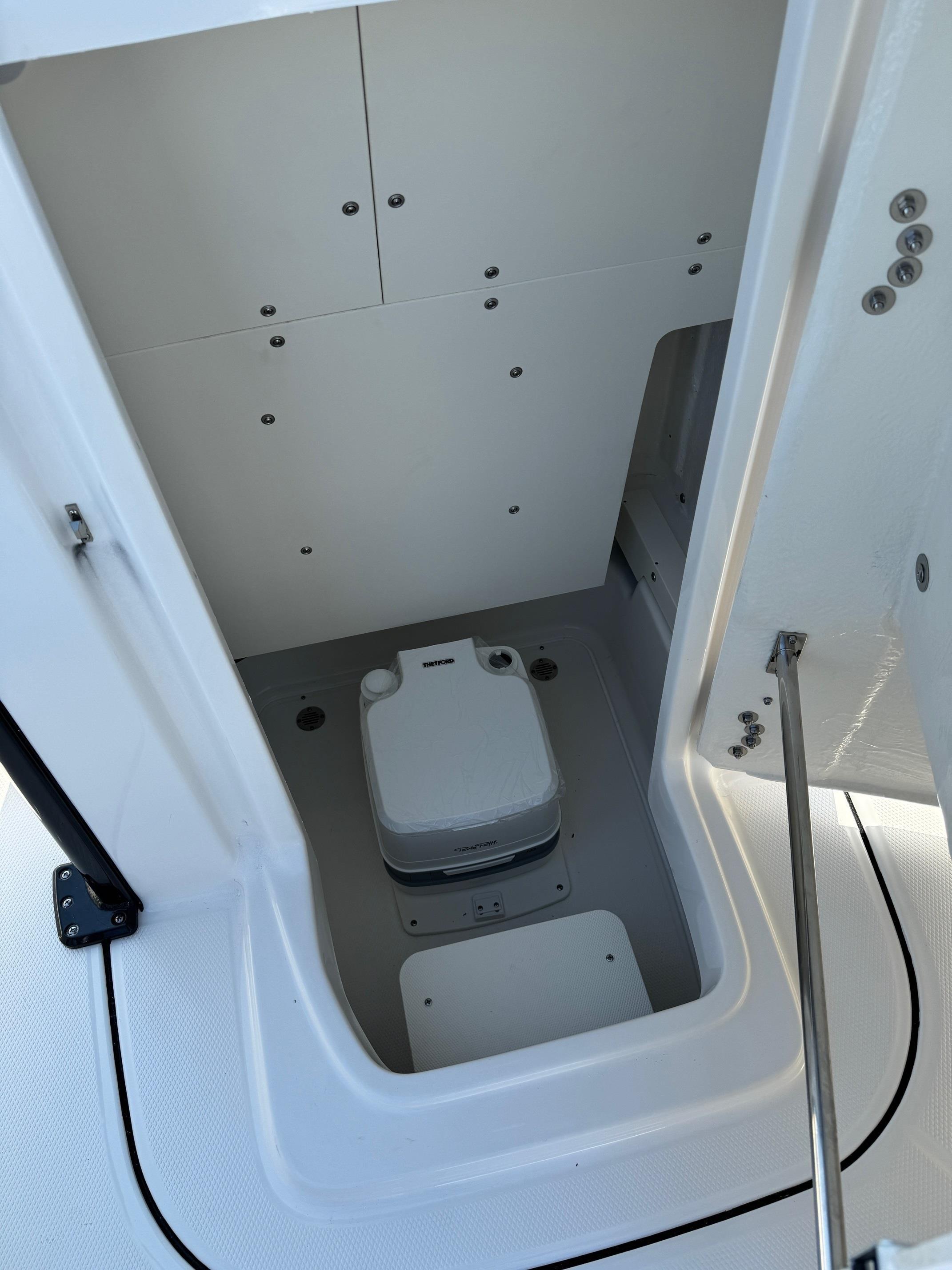2025 Robalo R246 CAYMAN boat interior with compact marine toilet.