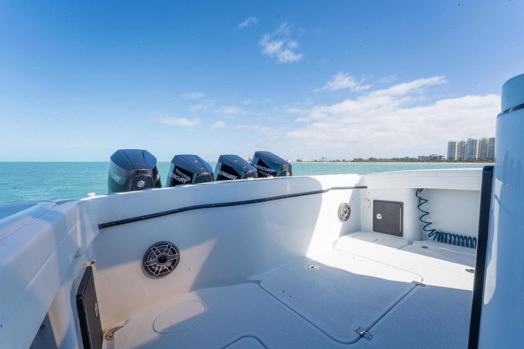 2024 Yellowfin 42 Offshore boat with Mercury engines, ocean view, and city skyline in the background.