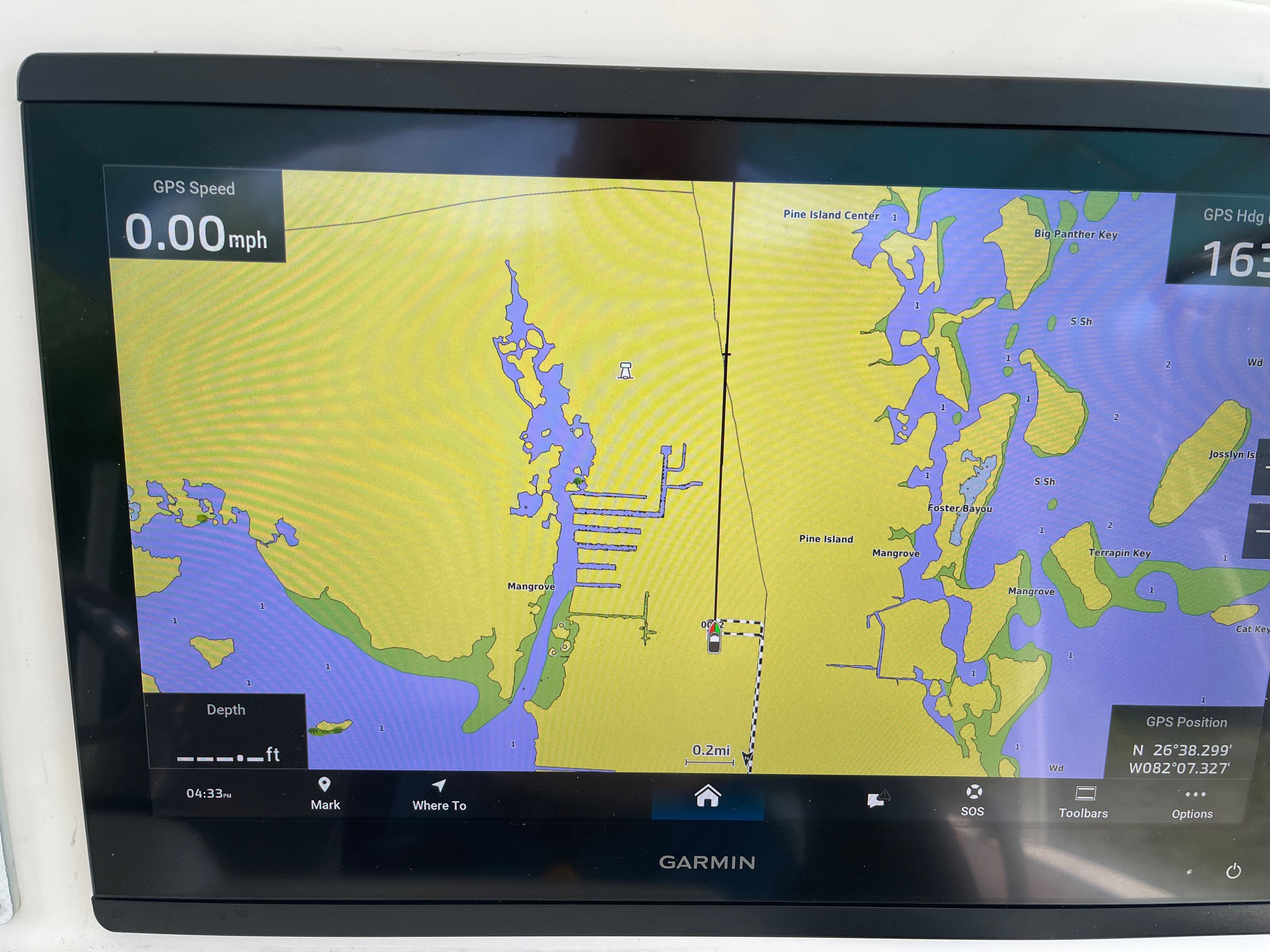 A Garmin GPS display shows a nautical chart with speed and depth information.