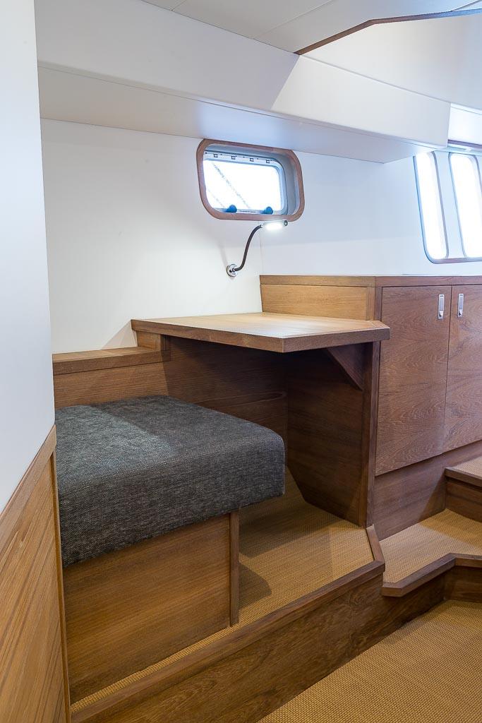 Interior of 2025 Deep Water Yachts Korvet 18 Long Range, featuring wooden seating and table.