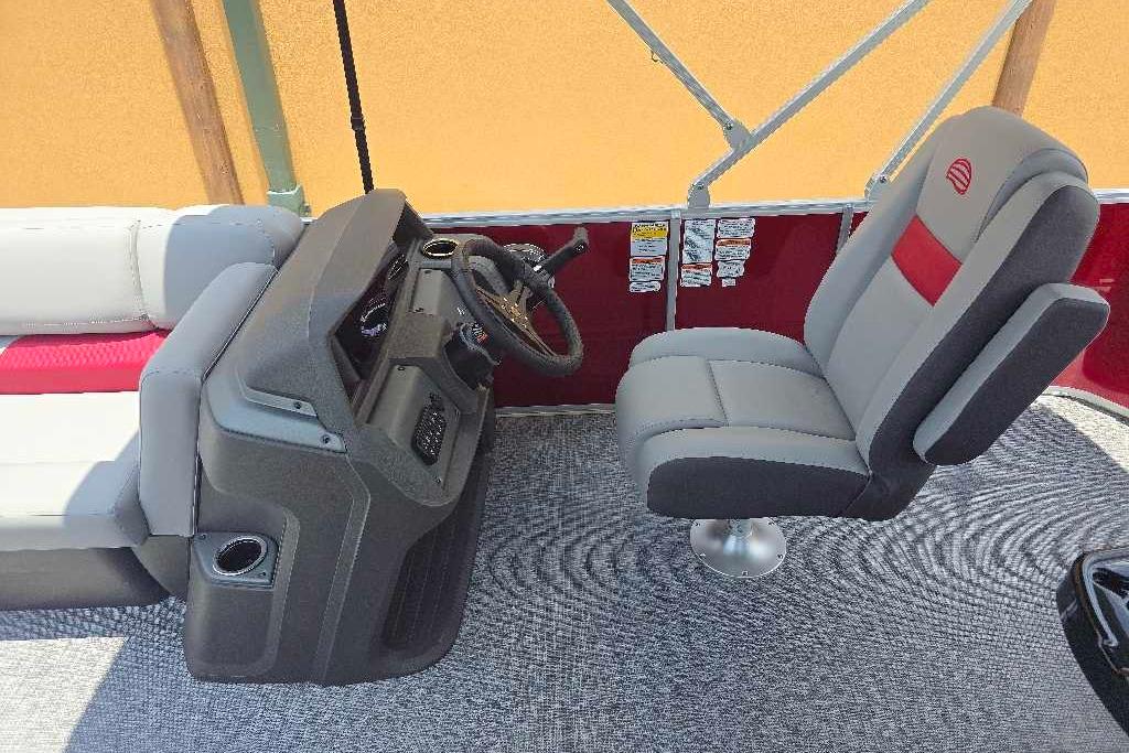 2026 Sun Tracker Party Barge 20 DLX interior with captain's chair and helm.