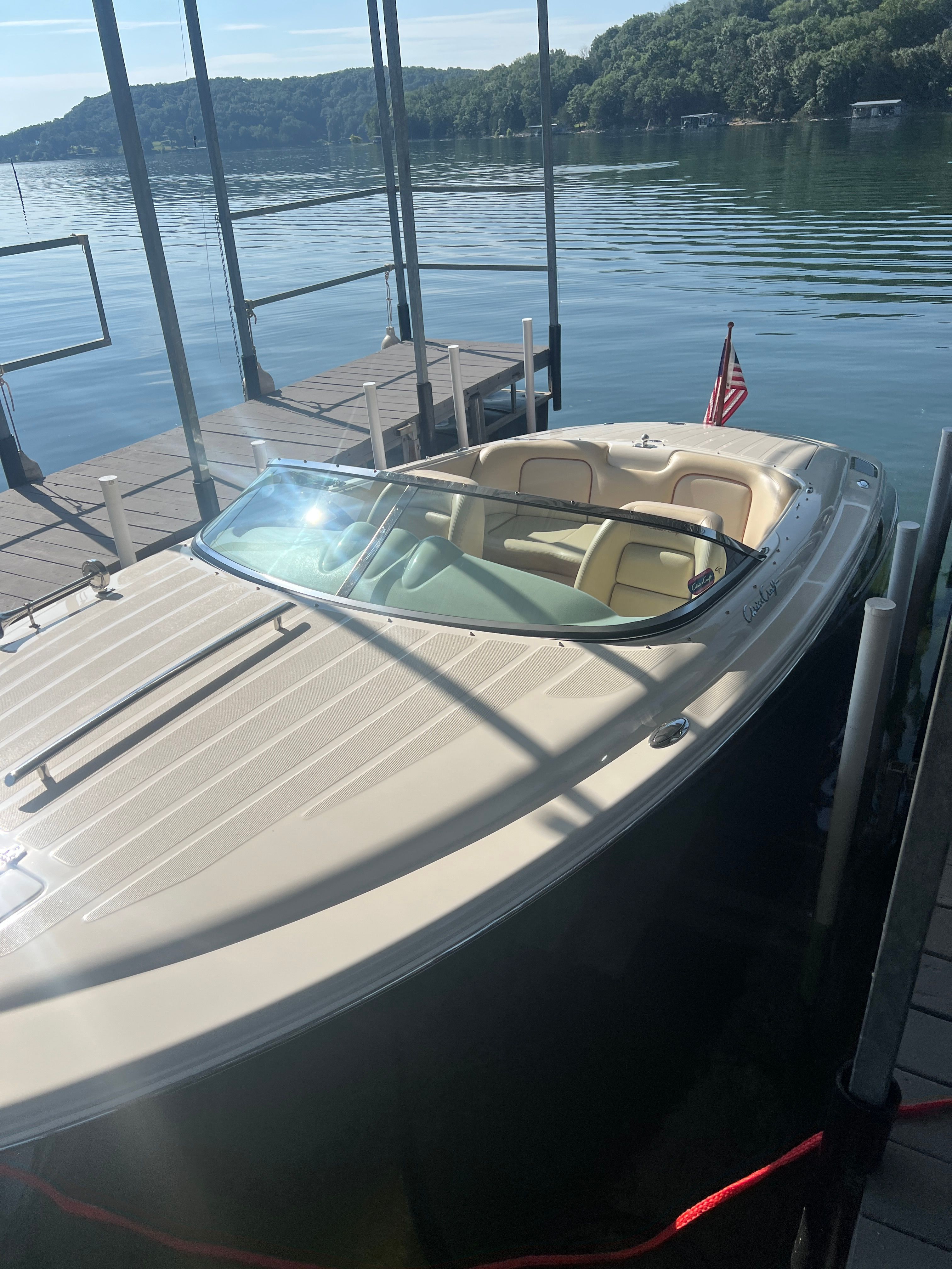 A 2006 Chris-Craft Speedster 20 docked at a calm lakeside.