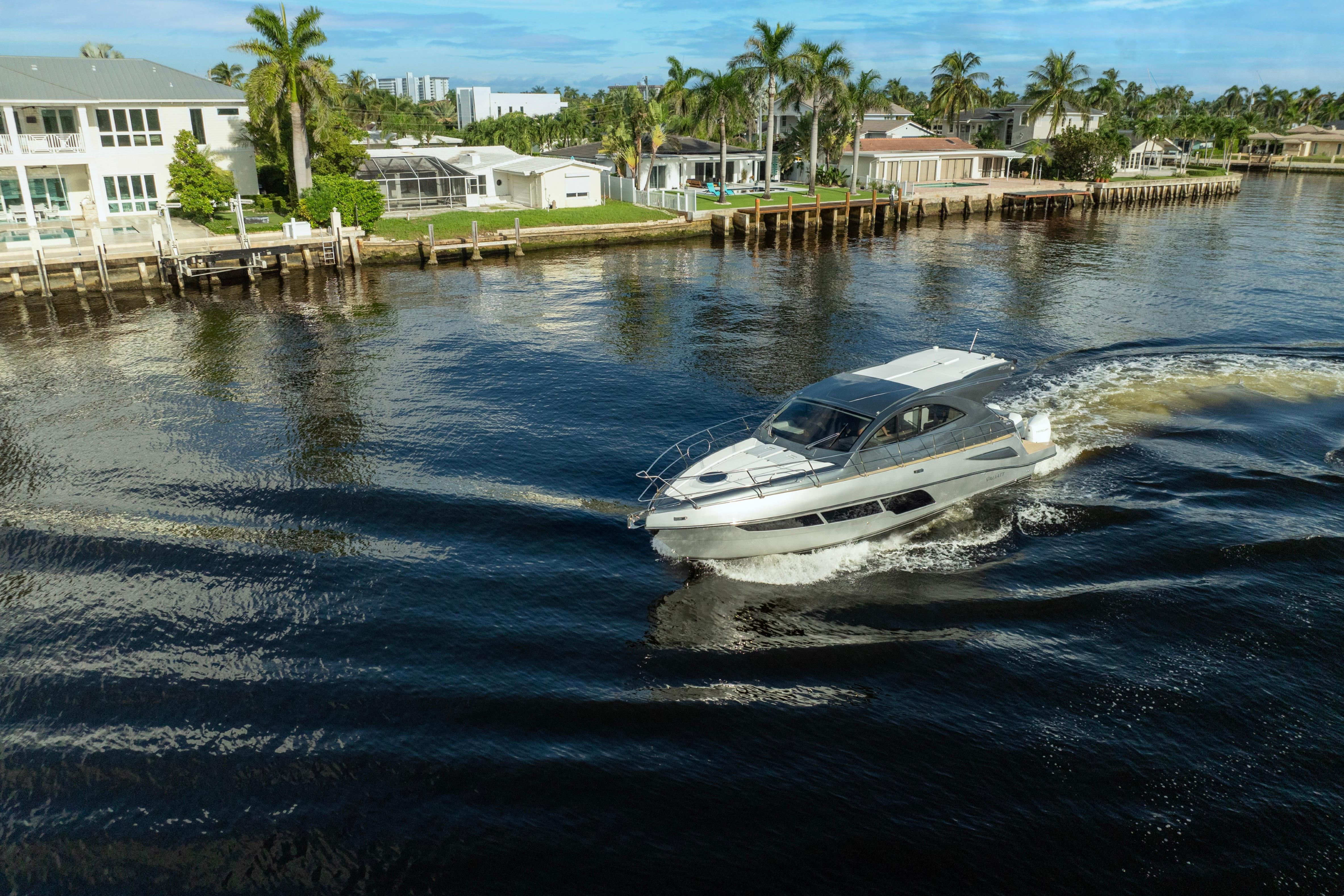 Luxury Valiatt 410HT yacht cruising near waterfront homes, 2025 model.