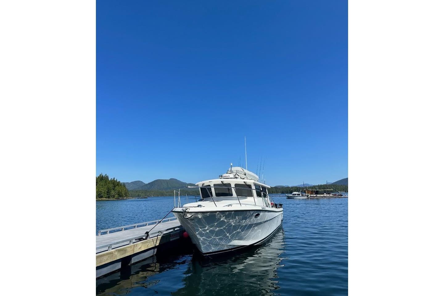 2017 Lindell Navigator 42 docked on a serene lake under clear blue skies.