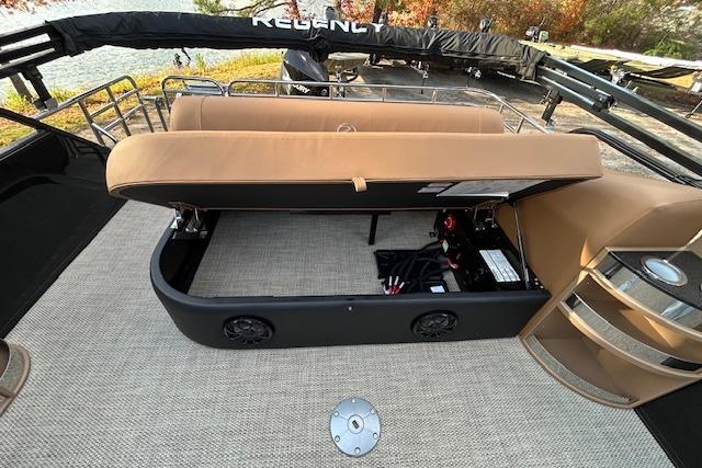 2025 Regency 230 LE3 Sport boat interior with open storage compartment and seating.