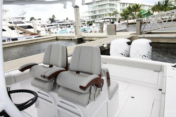 2024 Jupiter 34 HFS boat interior with dual seats and twin outboard engines at marina.