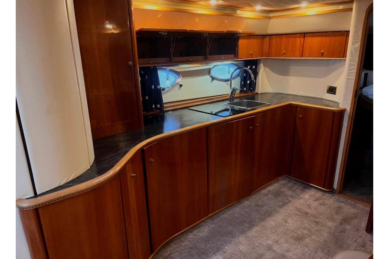 Luxurious wooden interior of a 1998 Princess V55 yacht kitchen with modern amenities.