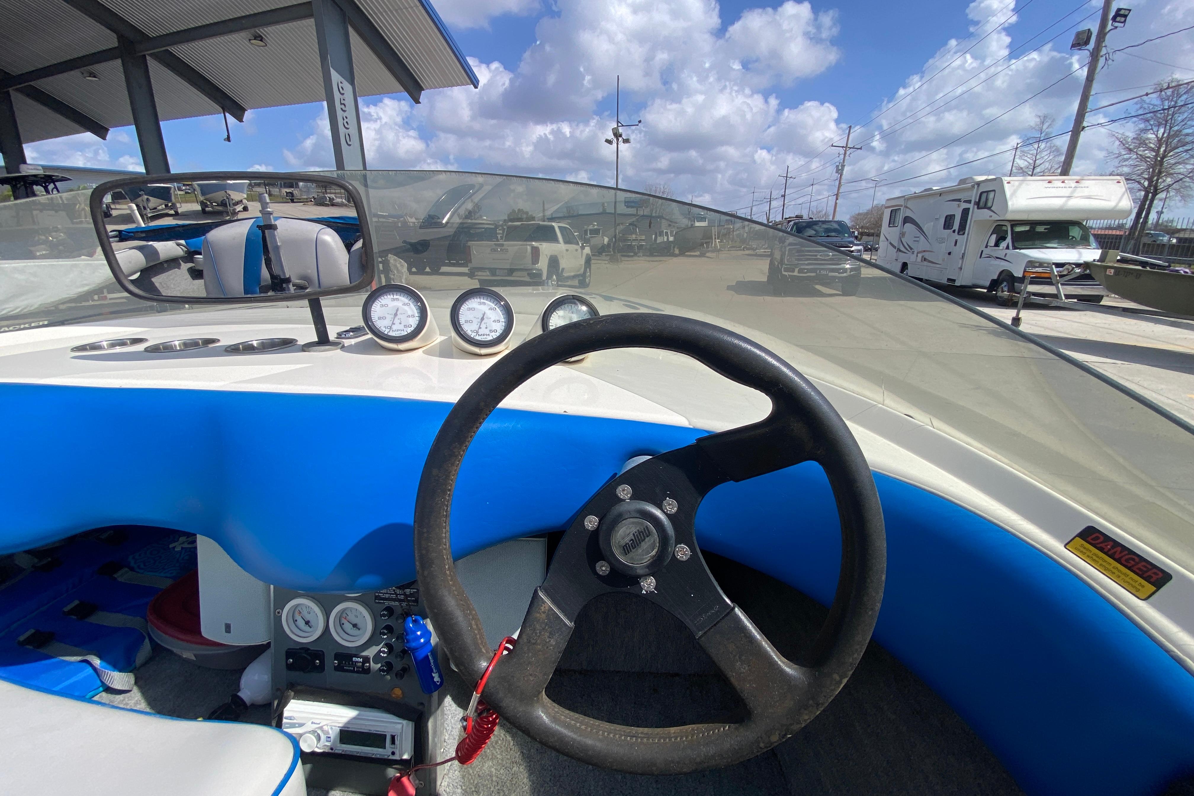 Interior view of a 1997 Malibu Tantrum boat with steering wheel and gauges.