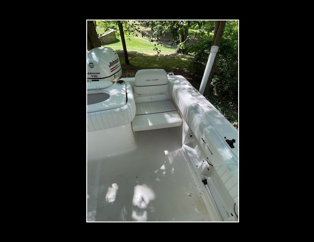 The image shows the cockpit of a 2004 Sea Hunt Escape boat with white seating.