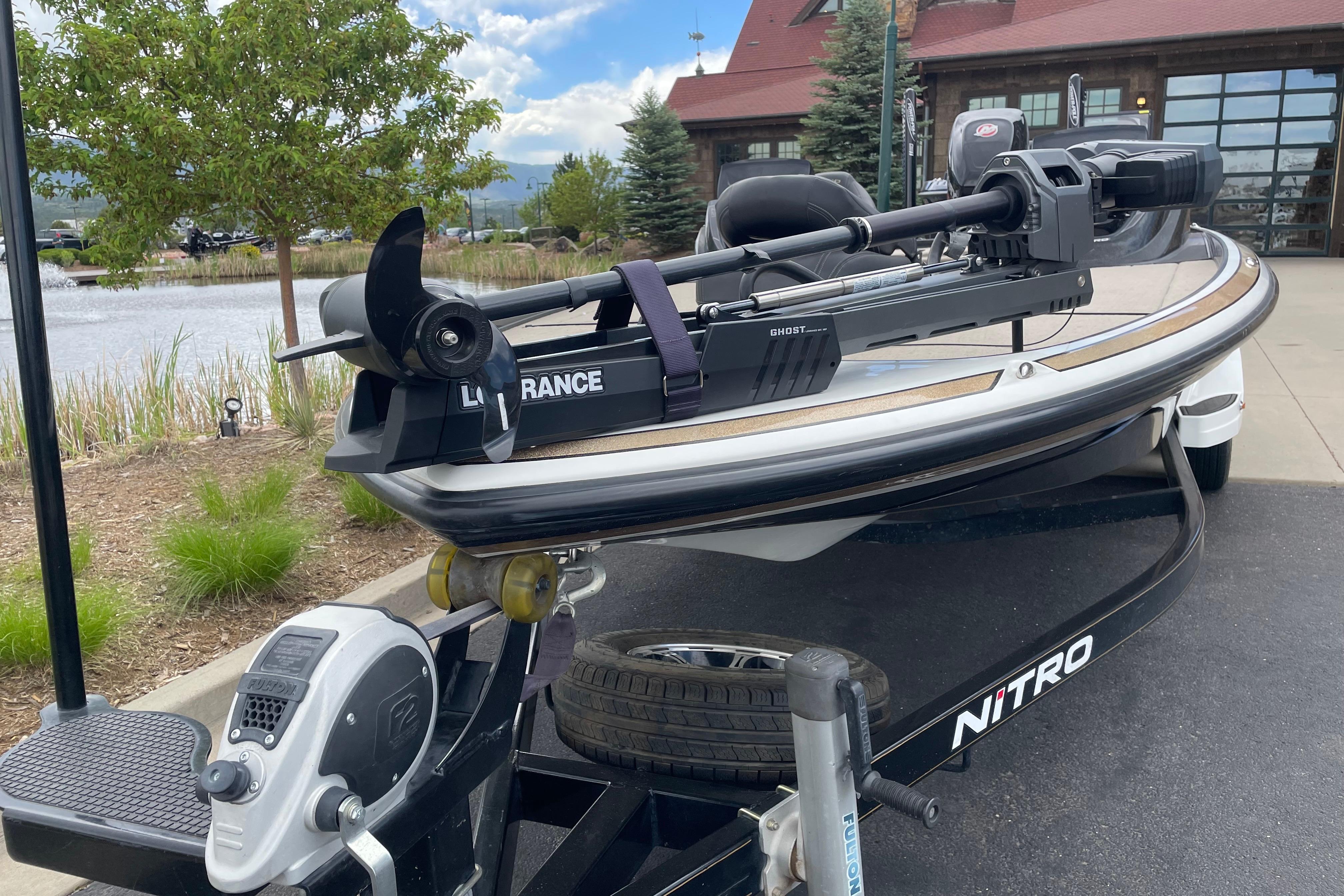 2016 Nitro Z21 boat with Lowrance equipment, parked near a scenic pond.