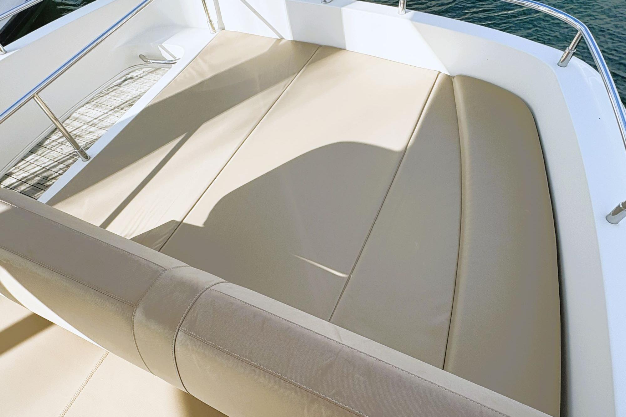 Luxurious seating on 2016 Carver C40 yacht, featuring beige cushions and stainless steel railings.