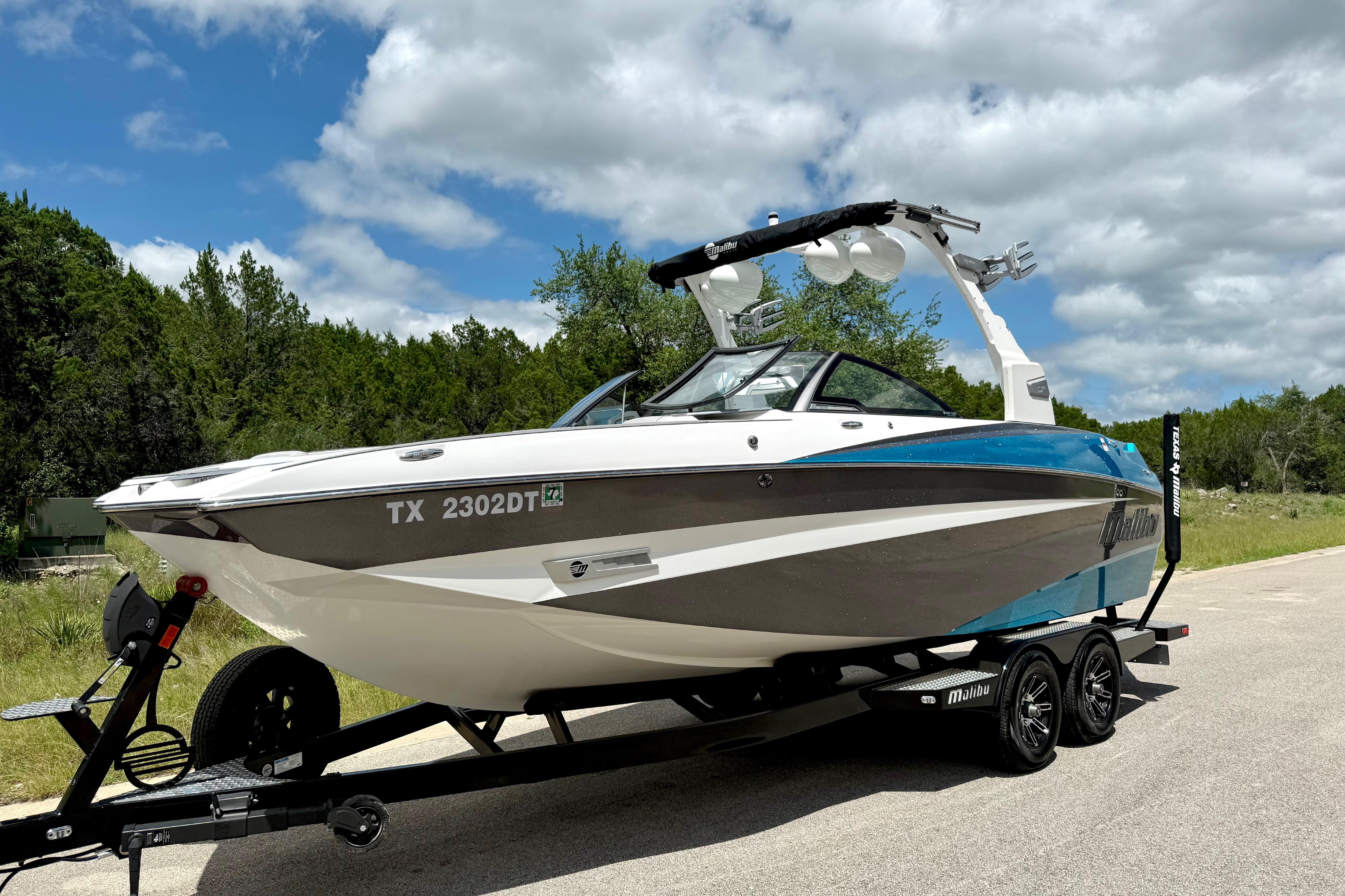 2017 Malibu M235 boat on trailer under a partly cloudy sky.