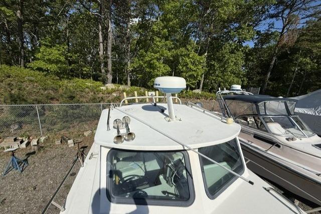2001 Parker 2520 Deep Vee Sport Cabin boat docked near trees and other boats.