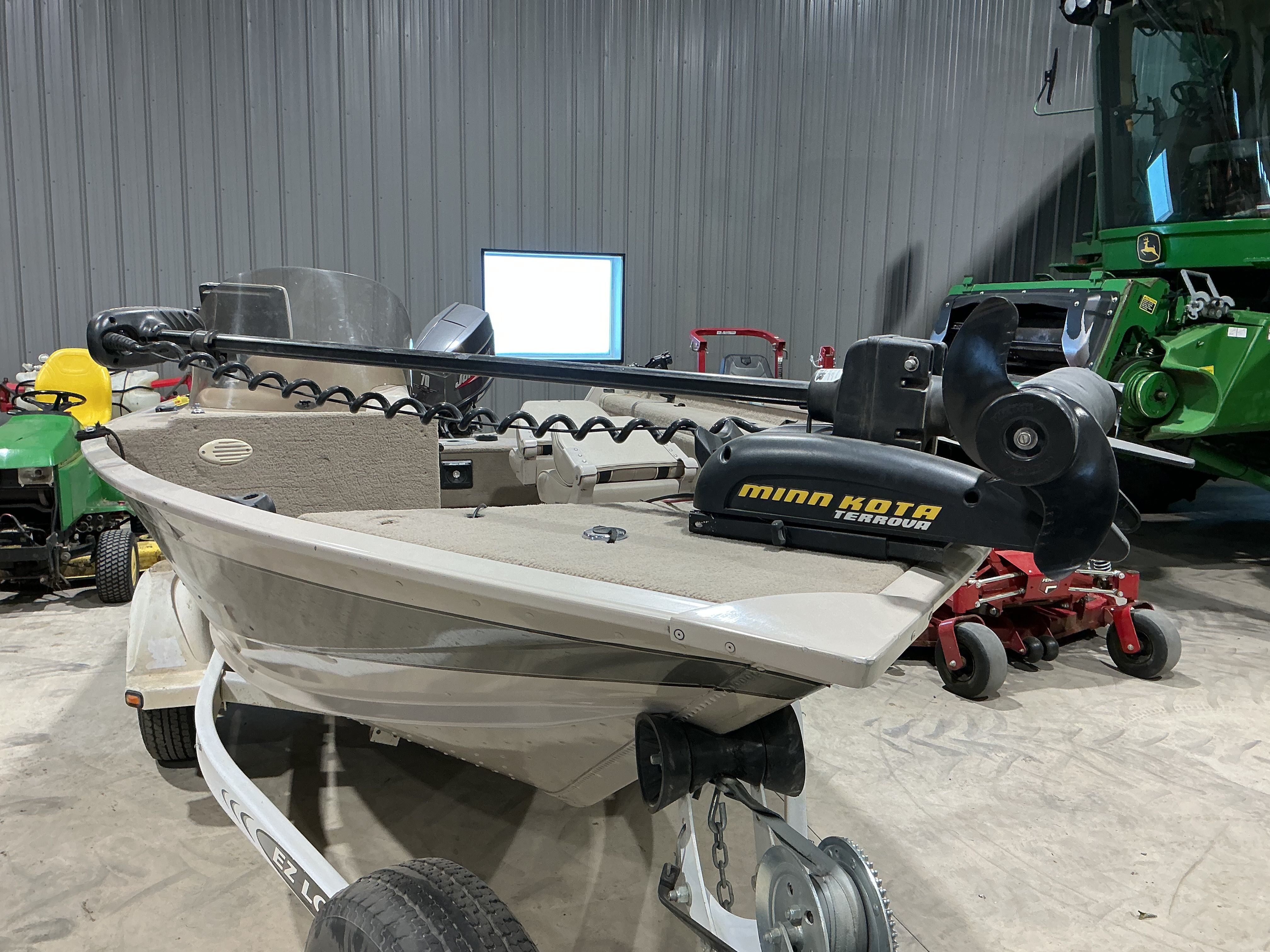 1999 Sylvan EXPEDITION boat with Minn Kota motor in garage.