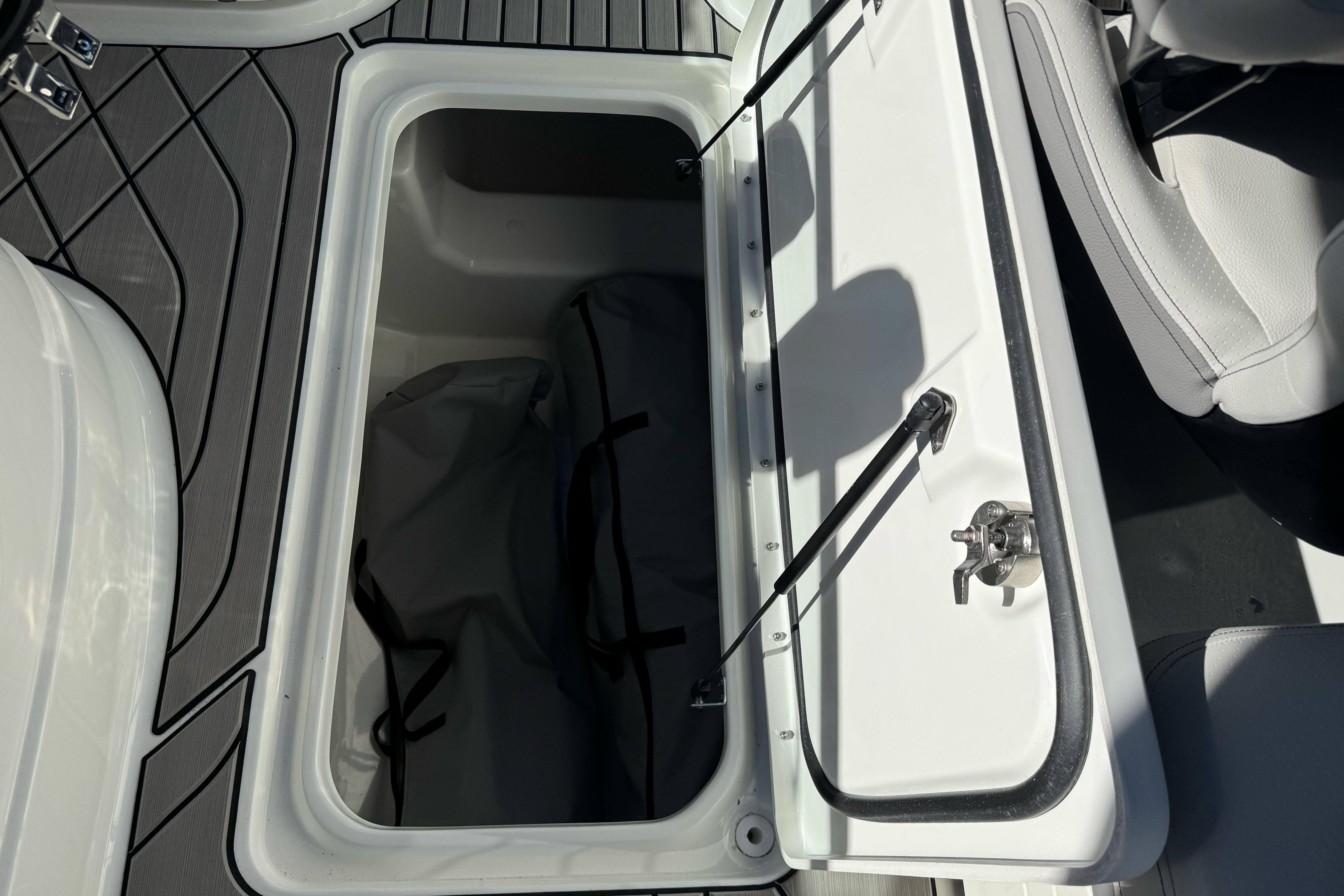 Open storage compartment on 2026 Sea Ray SLX 260 boat, featuring sleek interior design.