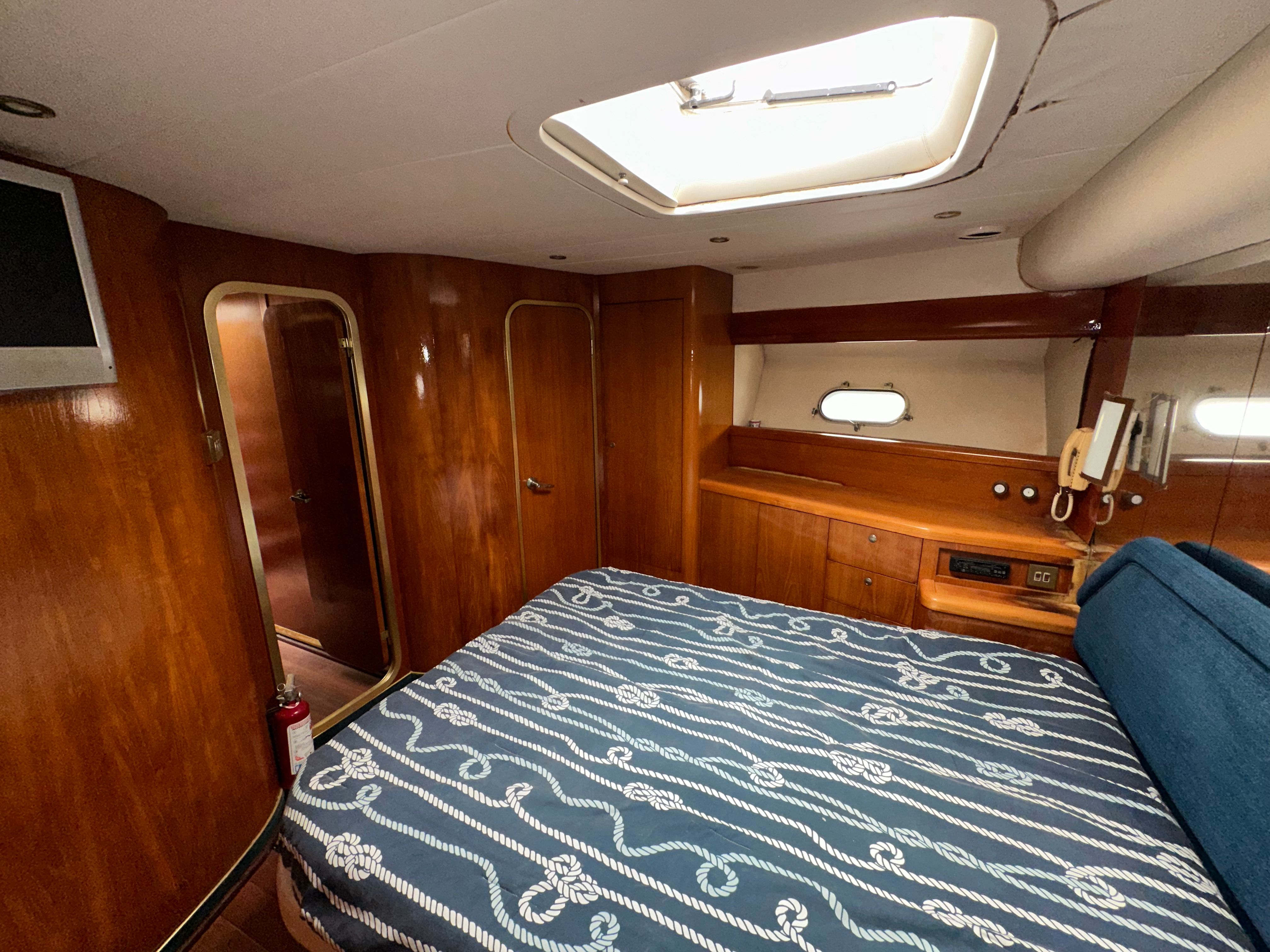 Interior of a 1991 Princess 65 yacht with wooden furnishings and bed.