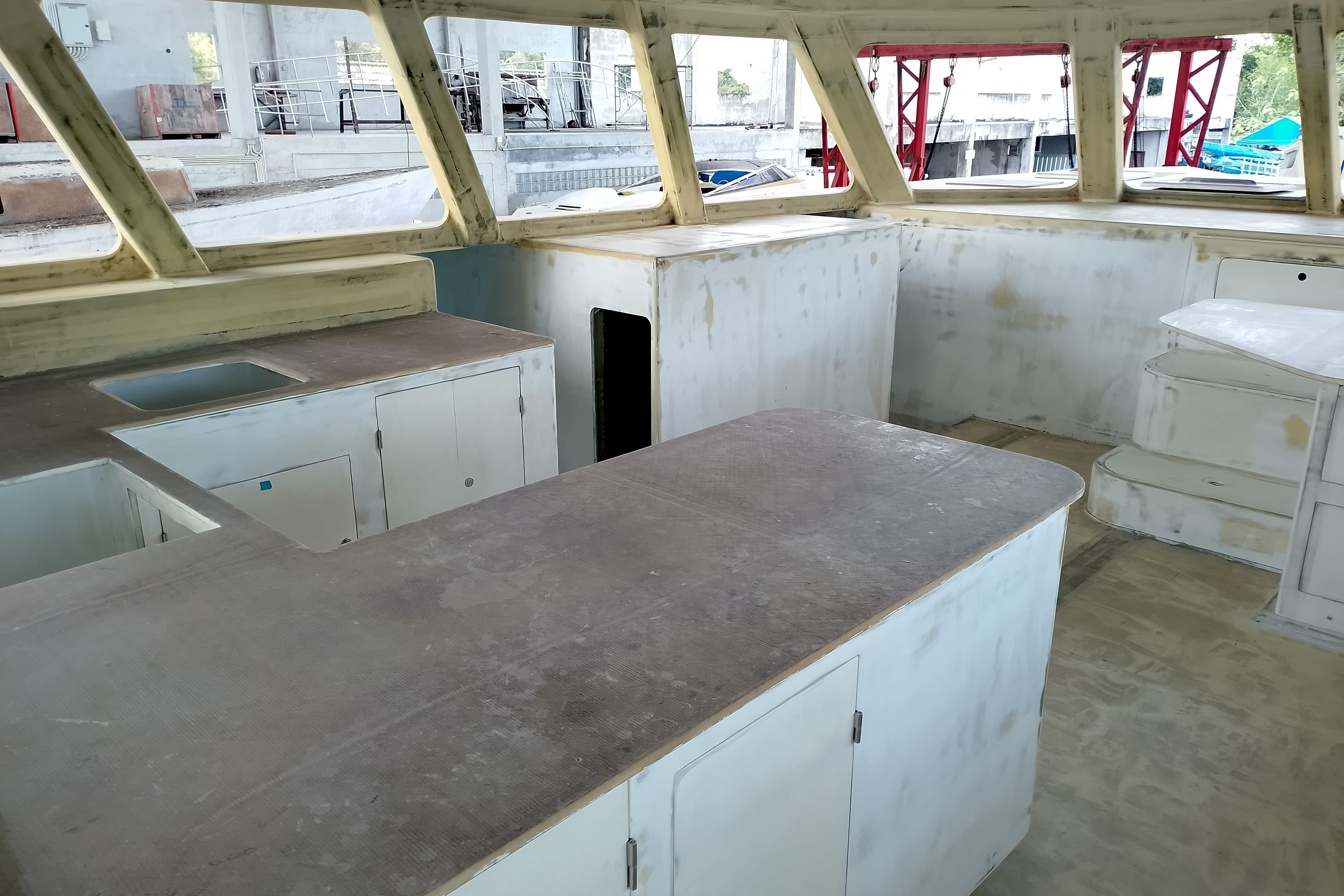 Interior of 2026 Schionning Prowler 1500 catamaran under construction, featuring unfinished kitchen area.