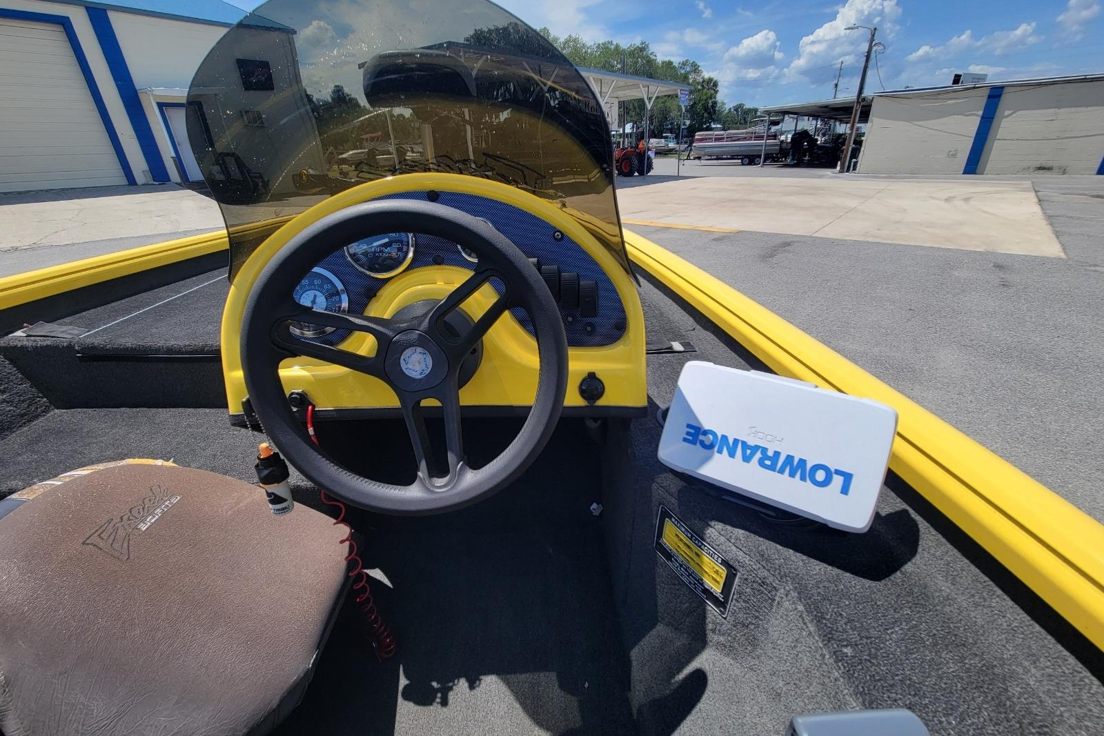 Interior of a 2011 Excel 1751 F4 boat with steering wheel and Lowrance device.