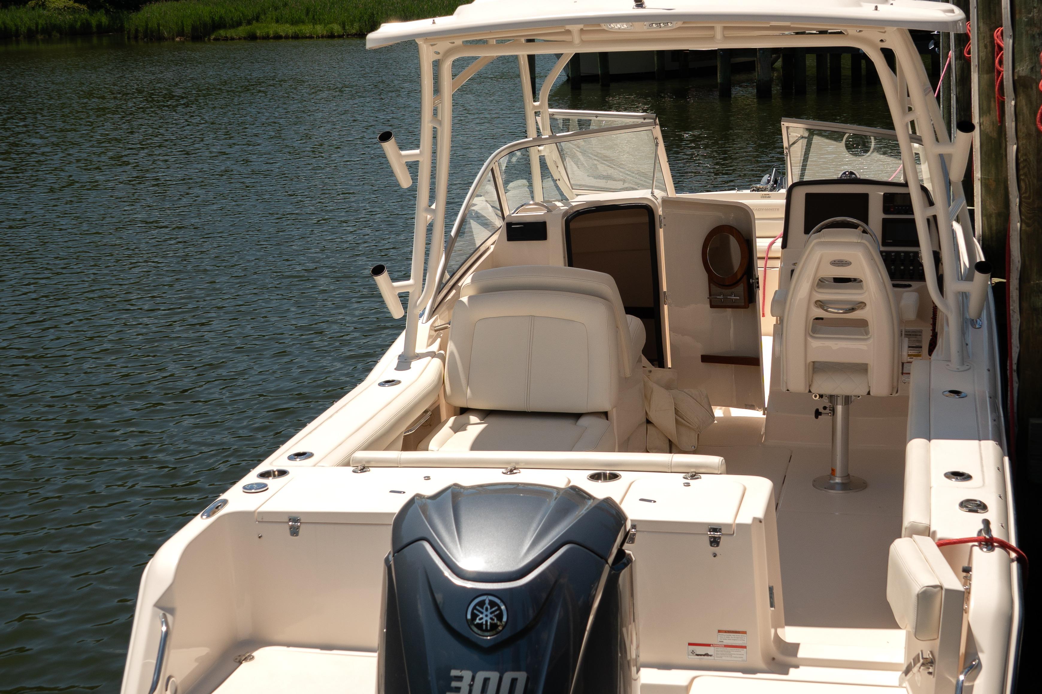 2022 Grady-White Freedom 235 boat interior with seating and controls, docked on calm water.