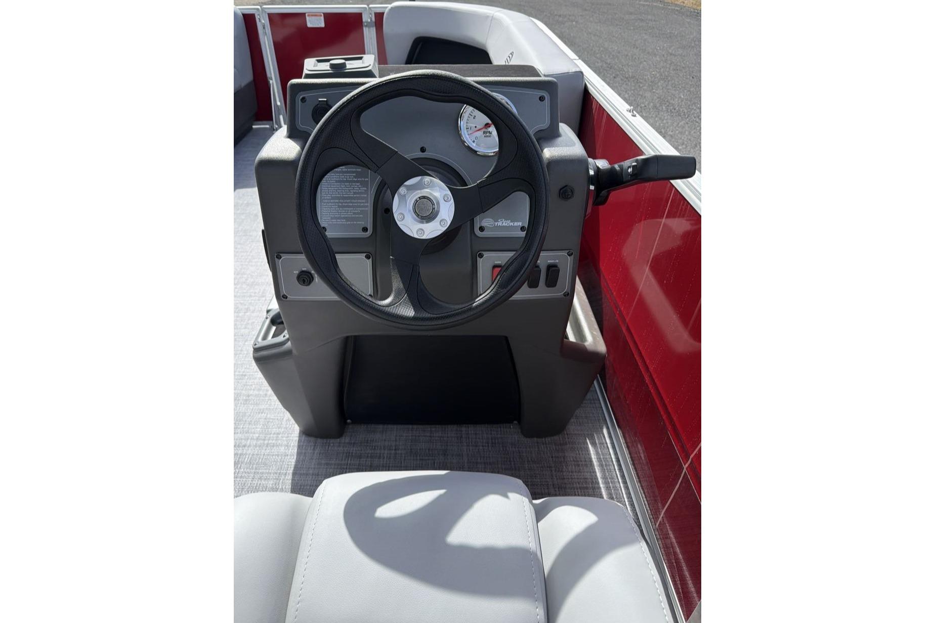 2026 Sun Tracker Party Barge 16 DLX steering console with red accents and modern controls.