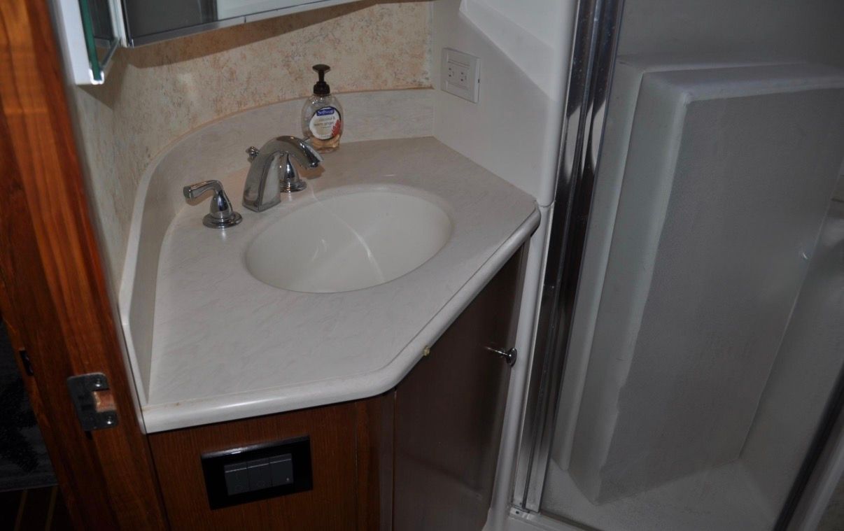 The image shows a bathroom with a sink, faucet, and shower enclosure.