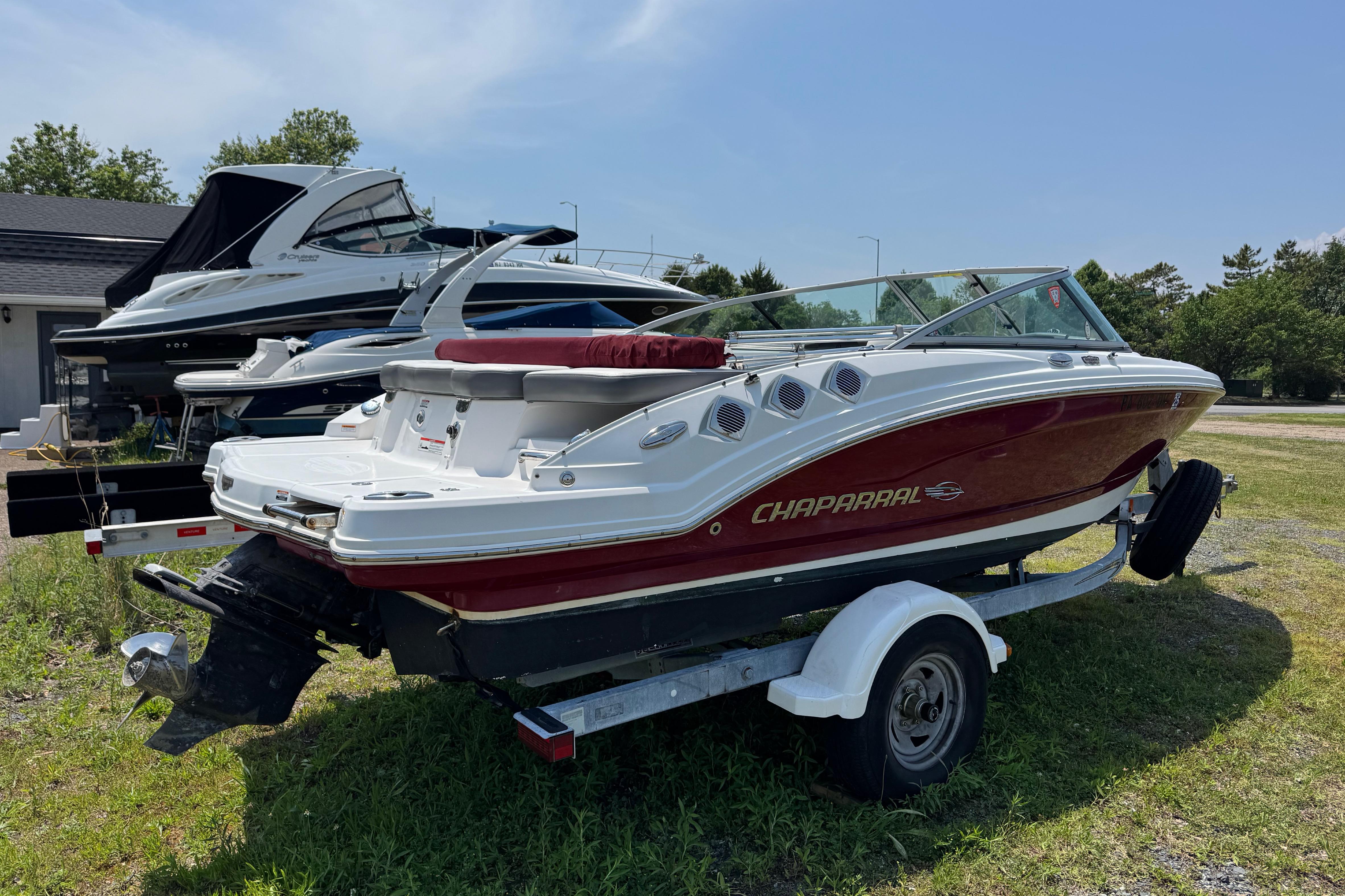 2013 Chaparral 196 SSi boat on trailer, parked outdoors on grass.