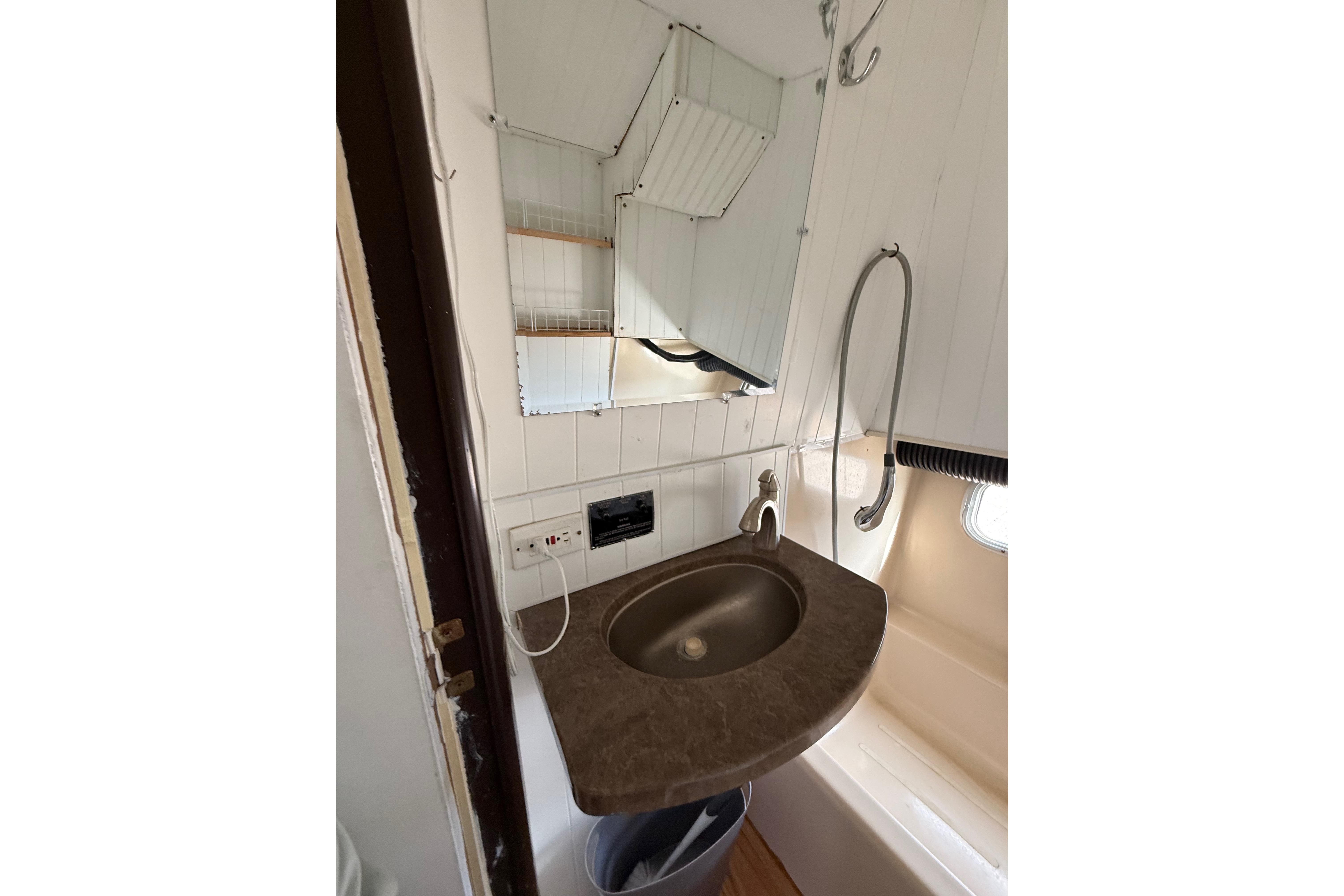 1983 Holiday Mansion 37 Barracuda bathroom with sink, mirror, and showerhead.