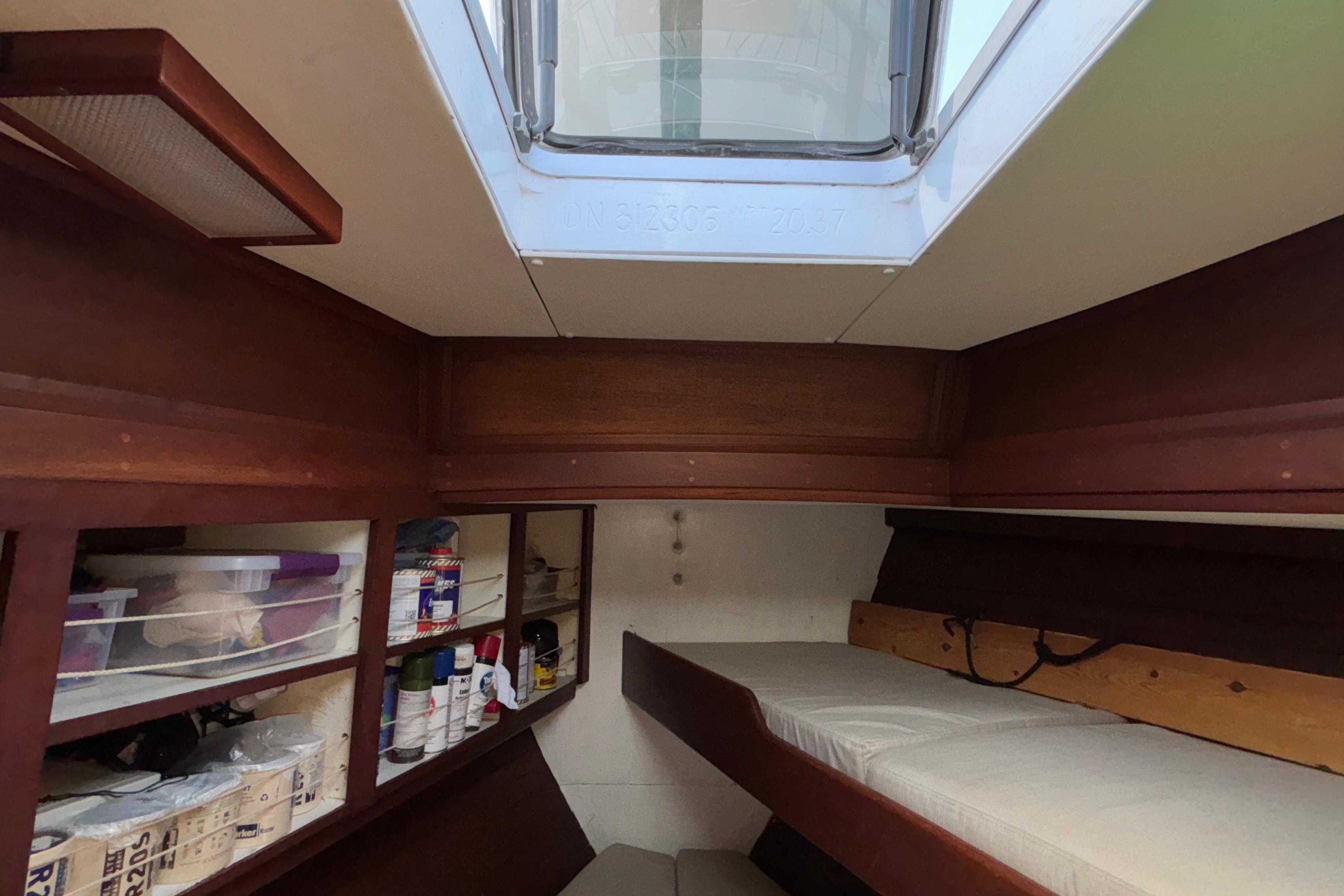 Interior of 1981 Bruce Roberts Offshore 45 sailboat with storage shelves and a skylight.