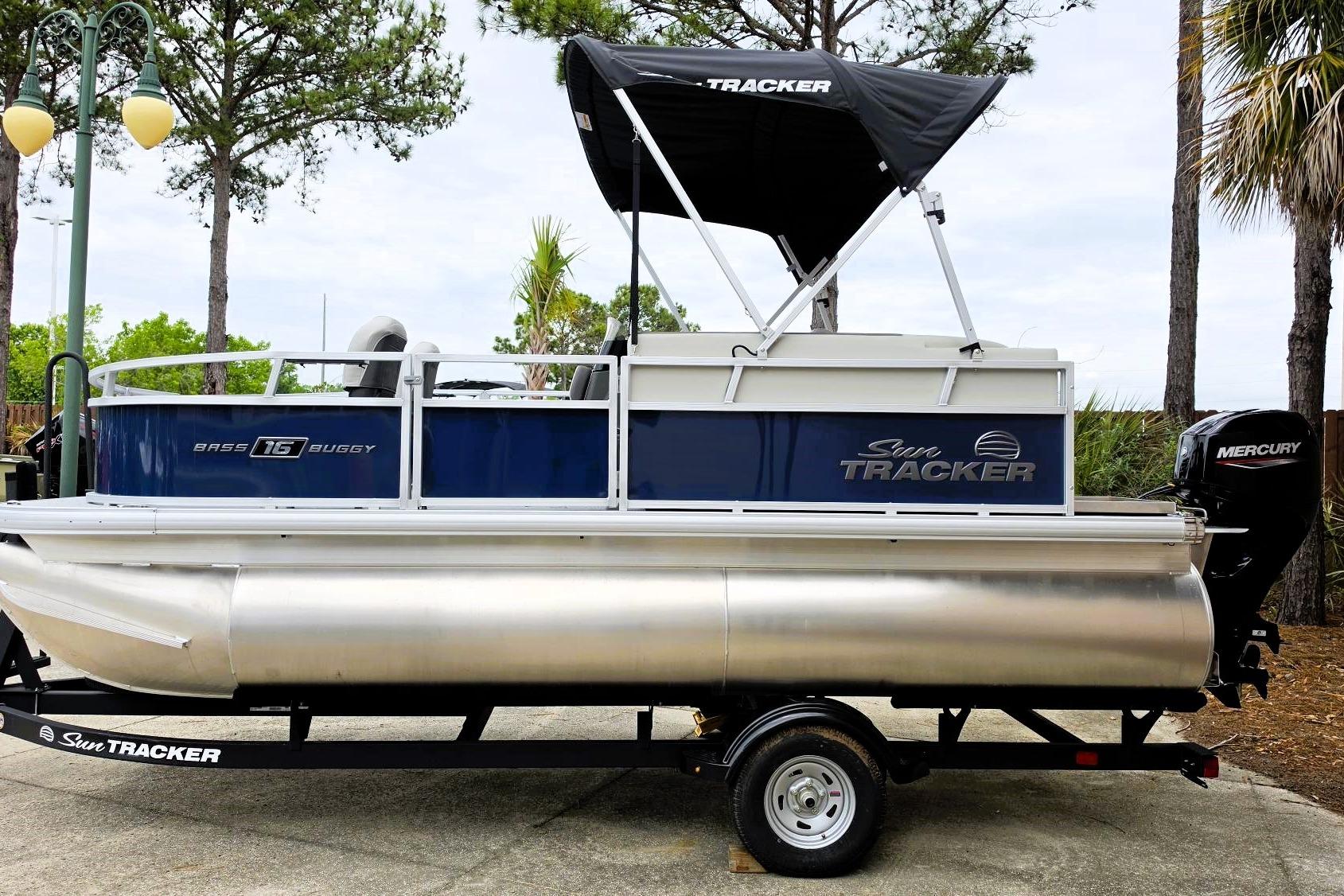 2026 Sun Tracker Bass Buggy 16 XL Select pontoon boat on trailer, side view.