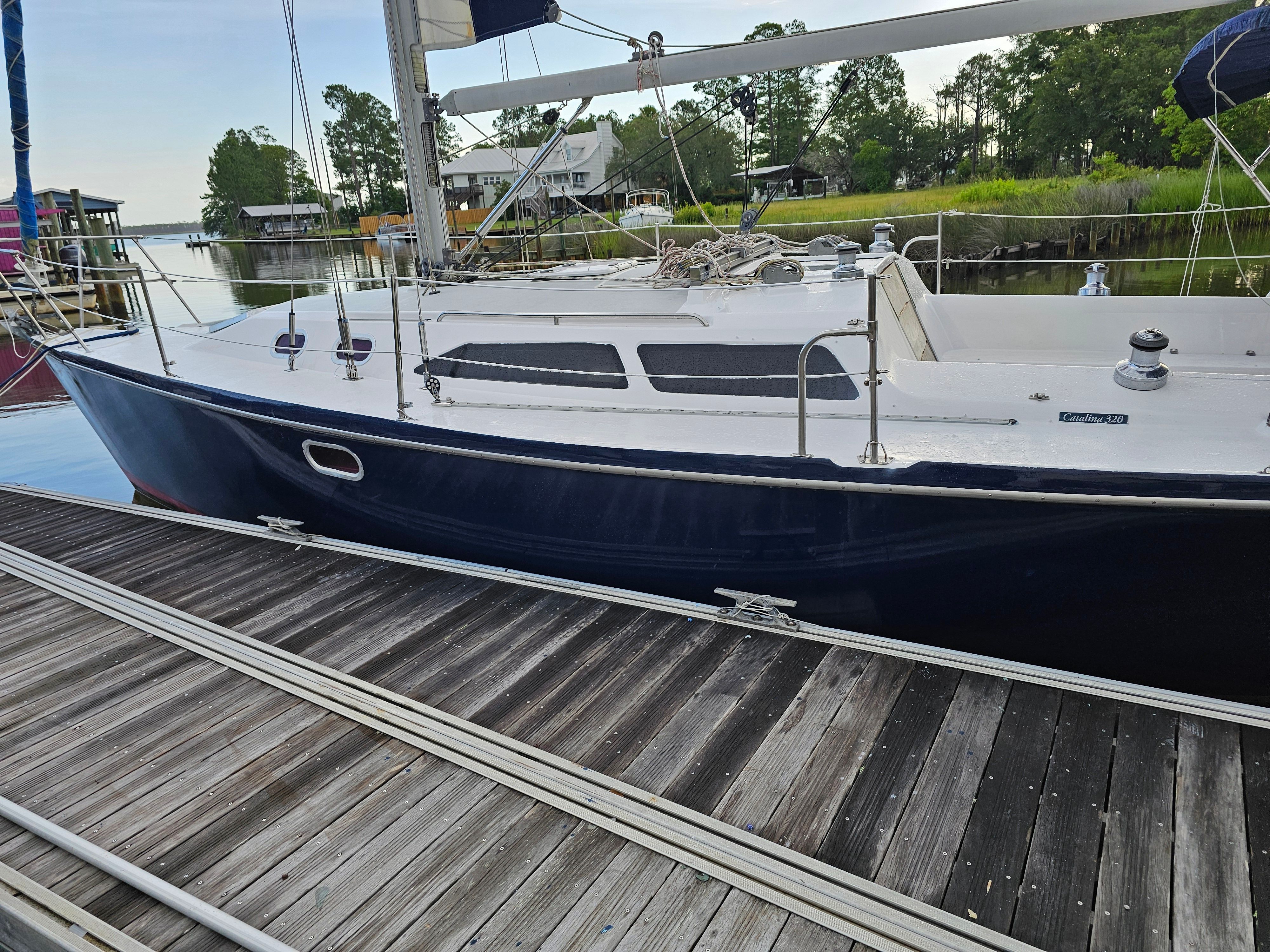2006 Catalina 320 sailboat docked, serene surroundings.