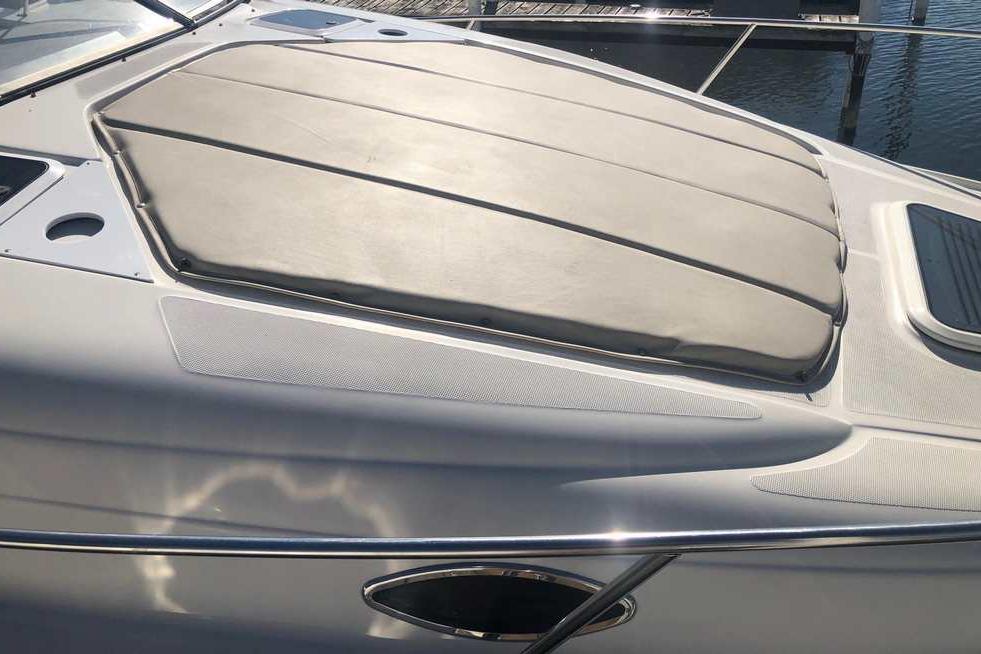 1999 Regal Commodore 2760 boat with cushioned deck, docked by the water.