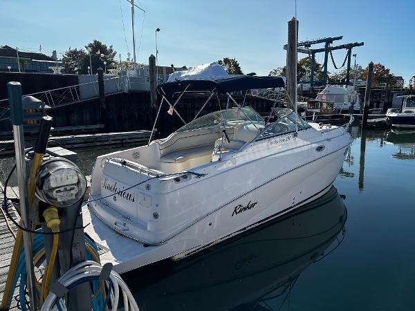 2004 Rinker Fiesta Vee 250 boat docked at marina, clear day, calm water.