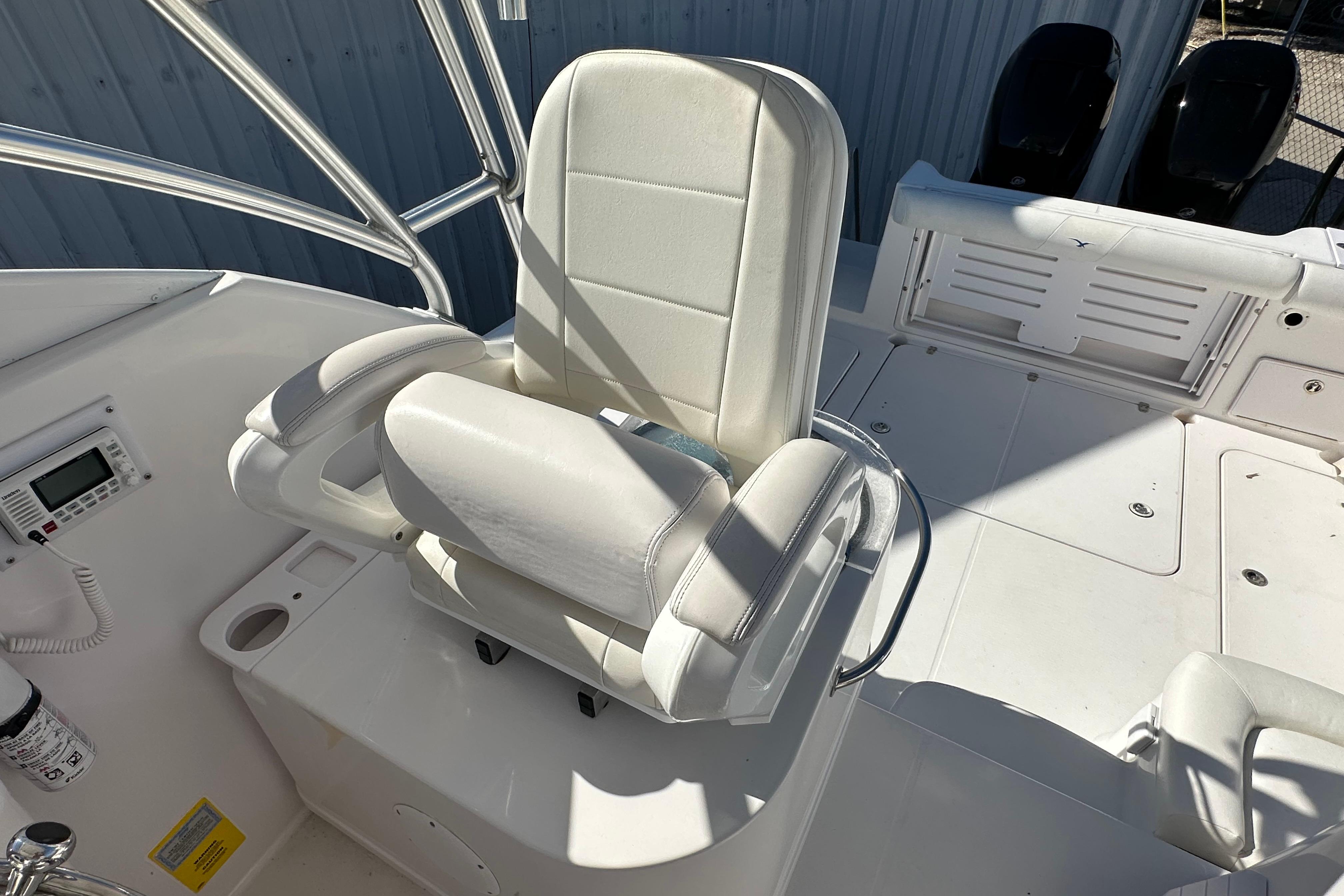 Captain's chair on 2006 Pro-Line 32 Express boat deck, featuring white upholstery and control panel.