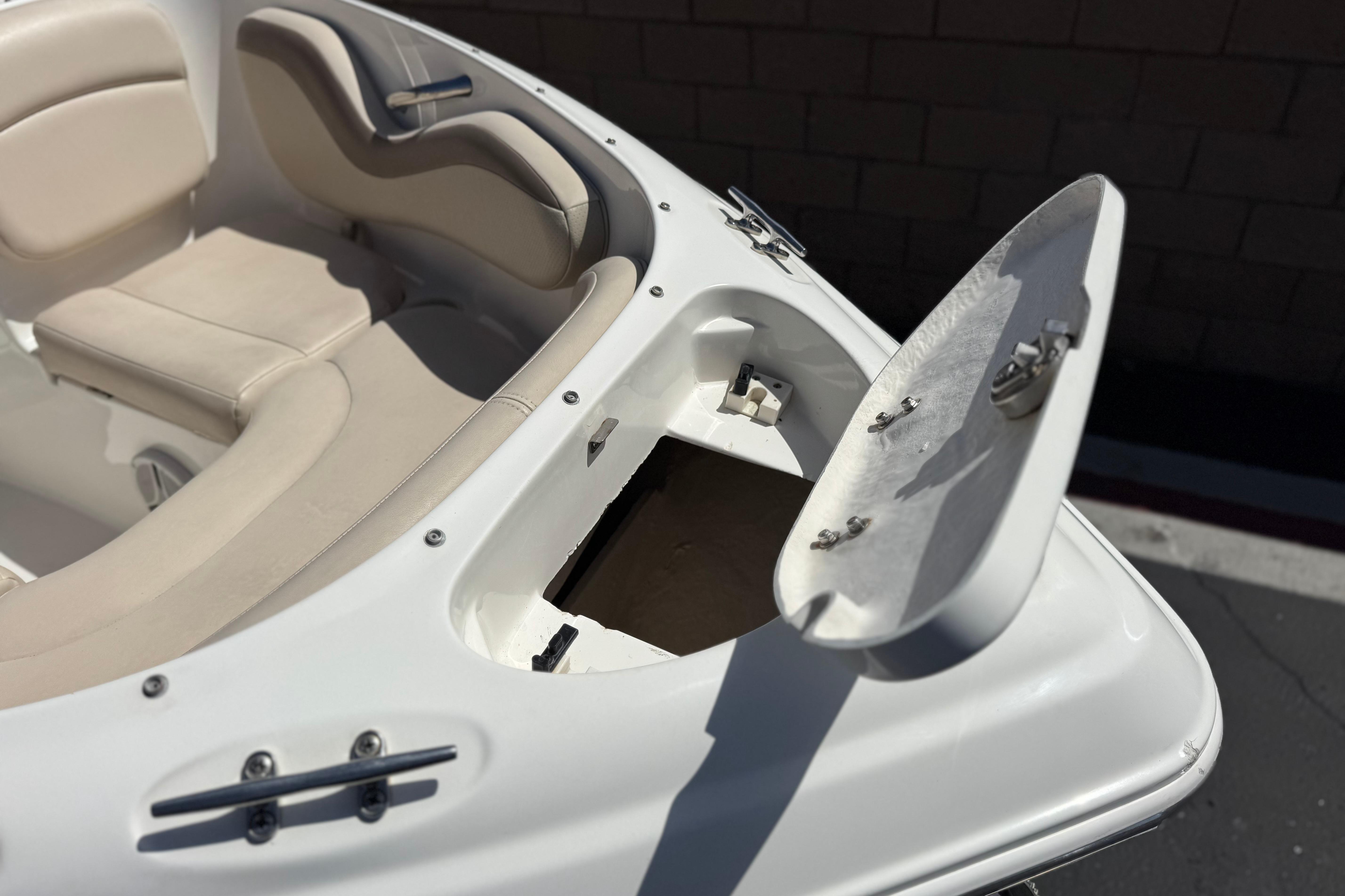 2006 Chaparral 190 SSi boat interior with open storage compartment and beige seating.