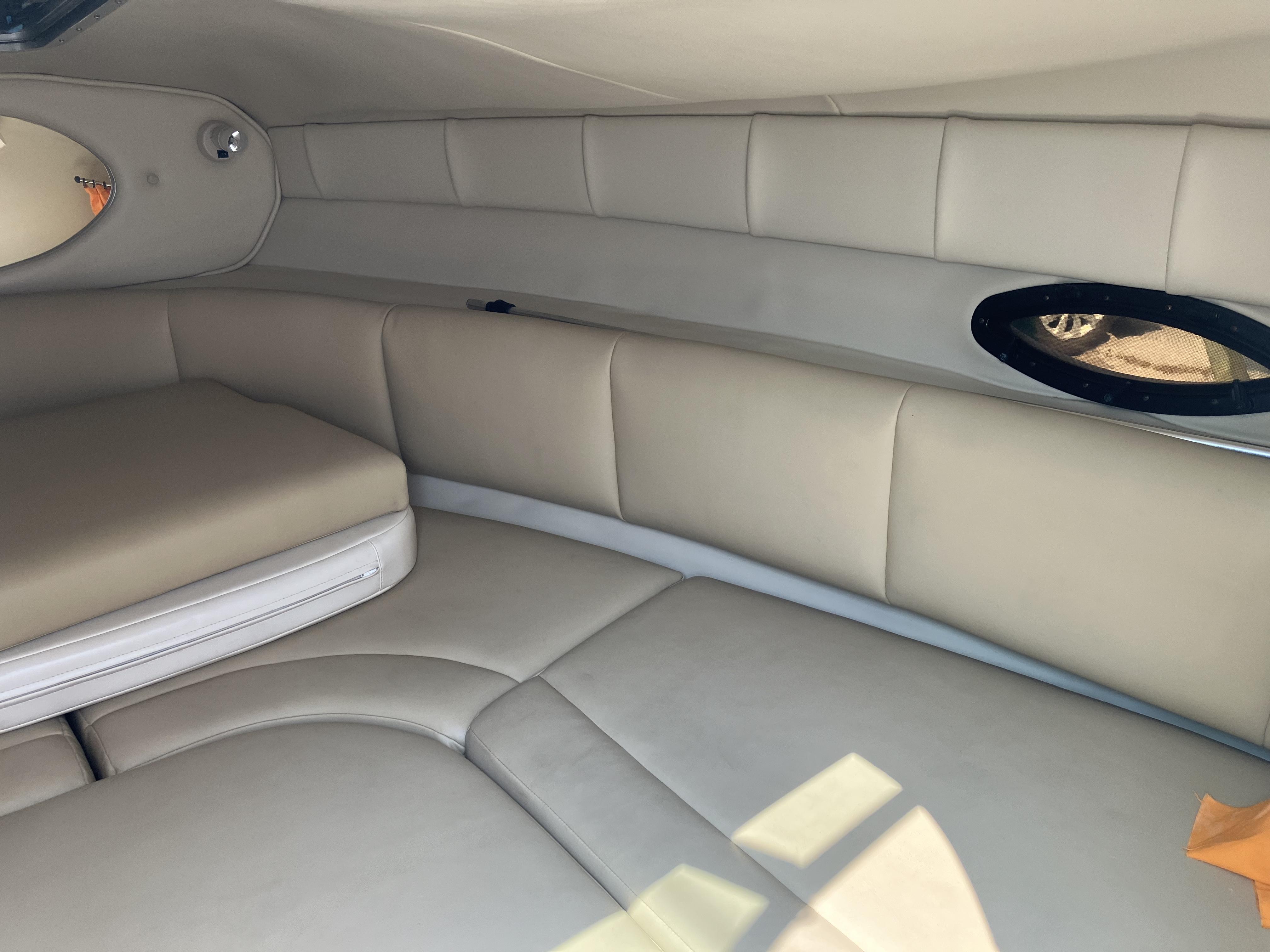 Interior of a 2001 Chaparral 235 SSi with beige upholstery and an oval window.