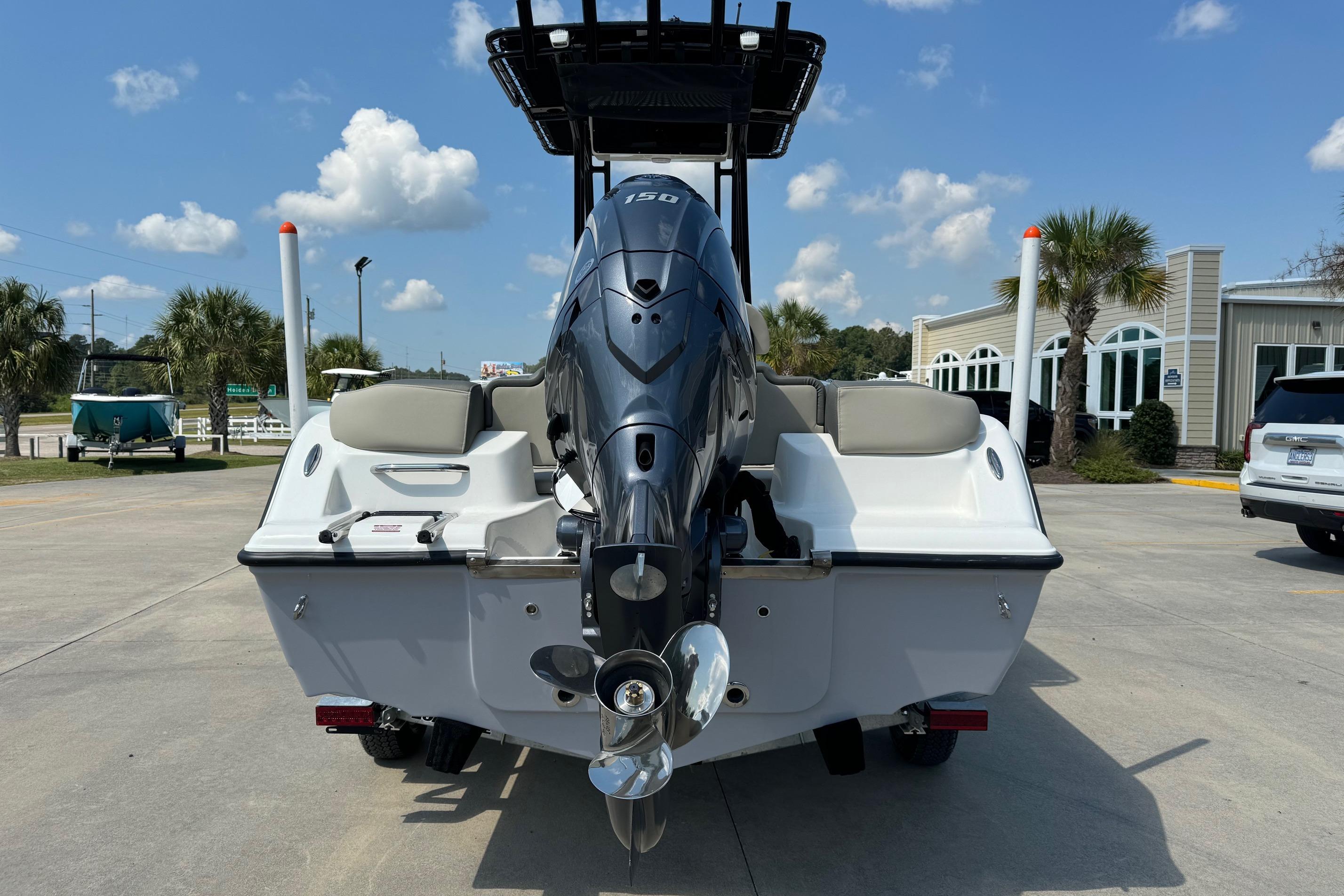 2025 Key West 203 FS boat with outboard motor, parked outdoors on a sunny day.