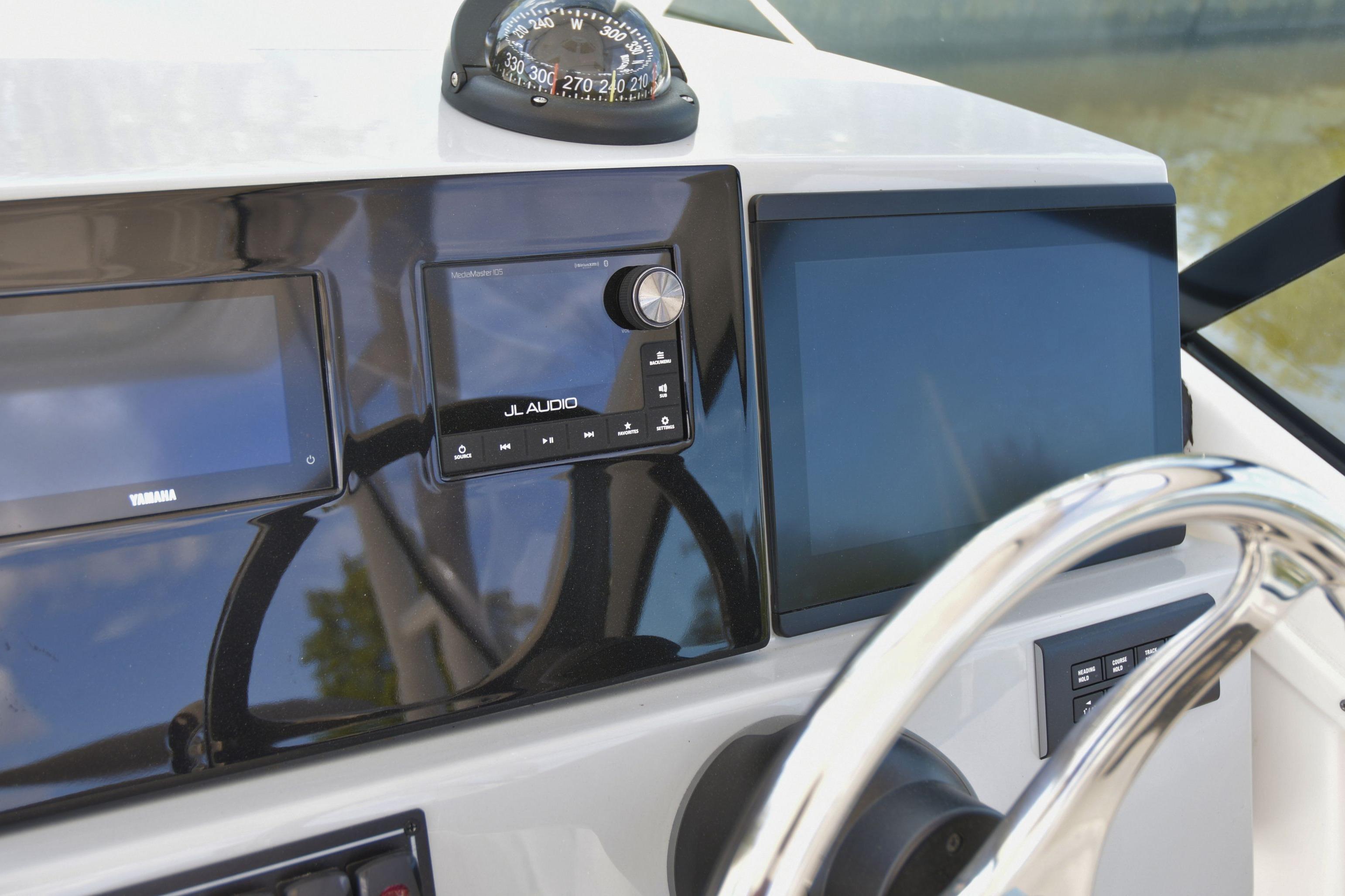 2024 Pursuit DC 246 Dual Console dashboard with compass, audio system, and steering wheel.
