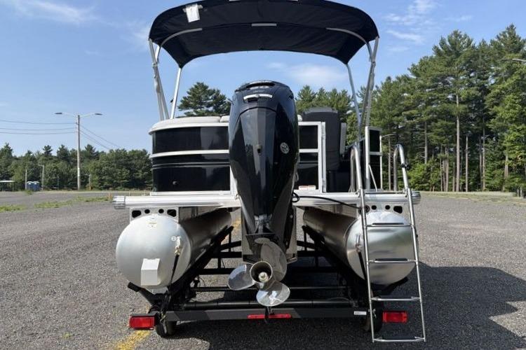2026 Sun Tracker Party Barge 20 DLX pontoon boat with canopy, parked on a trailer.