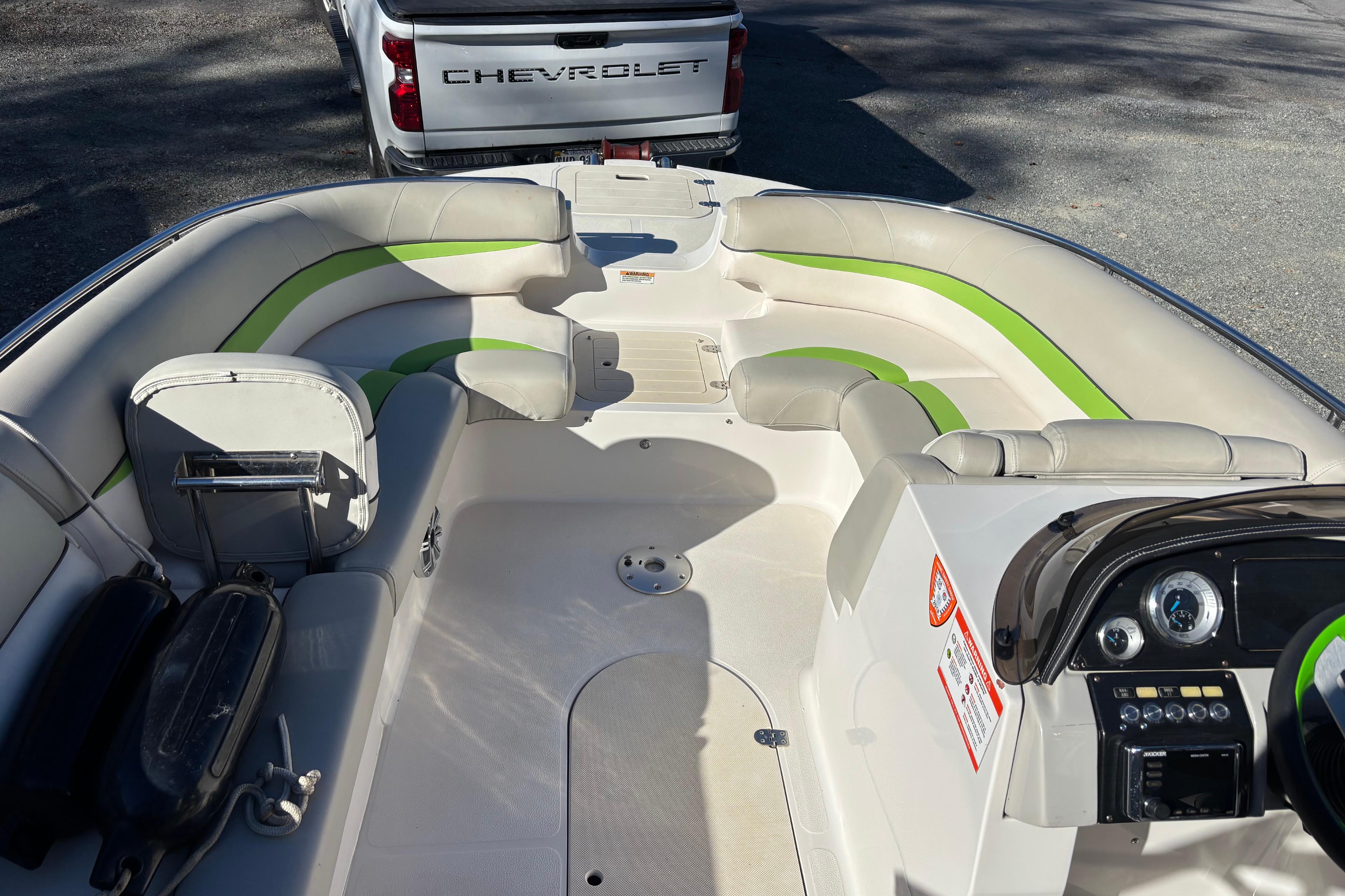 2018 Starcraft Star Step 221 I/O boat interior with green accents, parked near a Chevrolet truck.