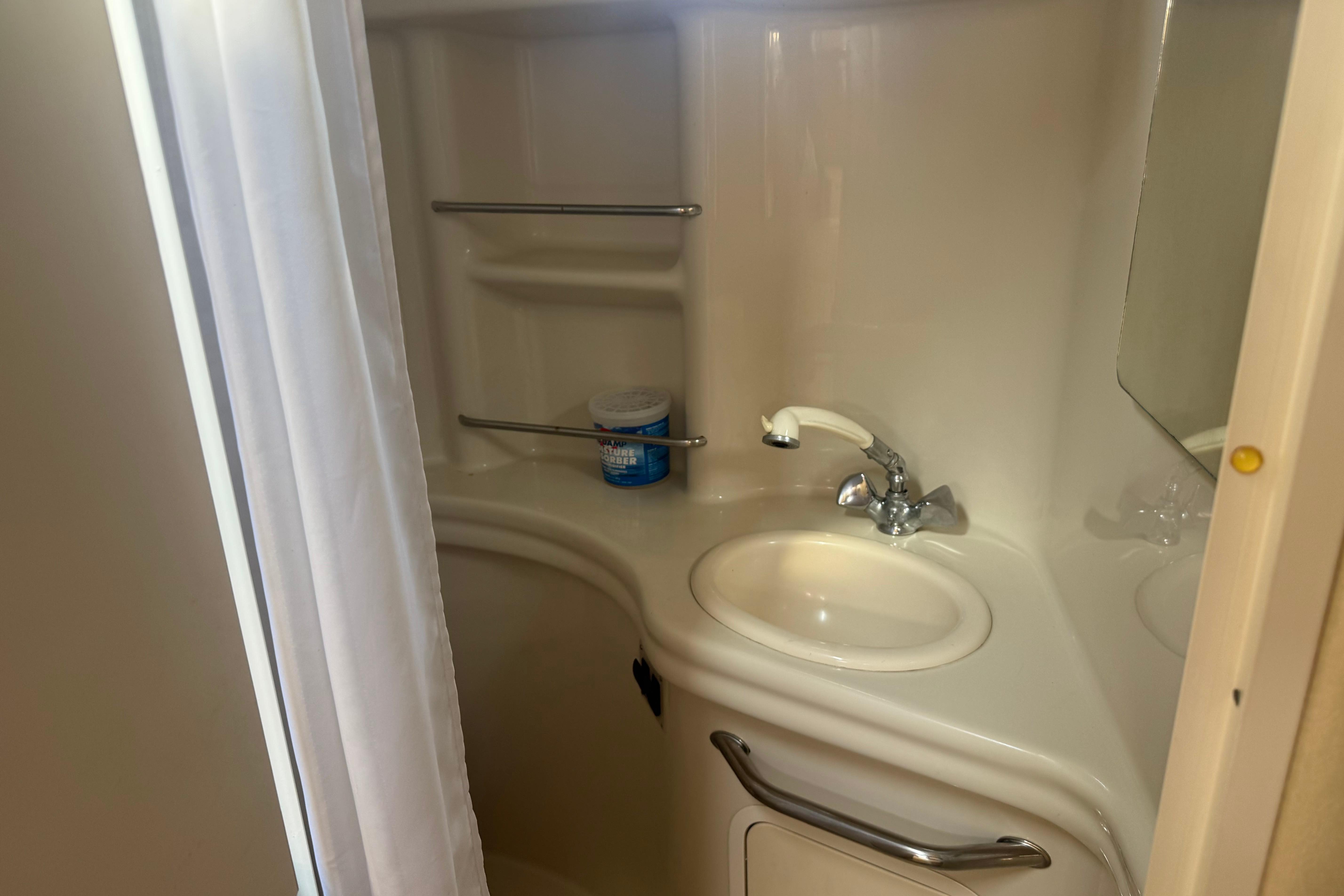 Bathroom interior of 2006 Sea Ray 300 Sundancer yacht with sink and storage shelves.