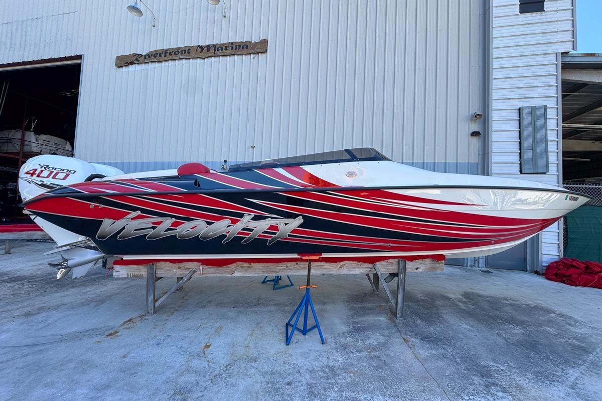 2022 Velocity 290sc speedboat with vibrant red and black design at Riverfront Marina.