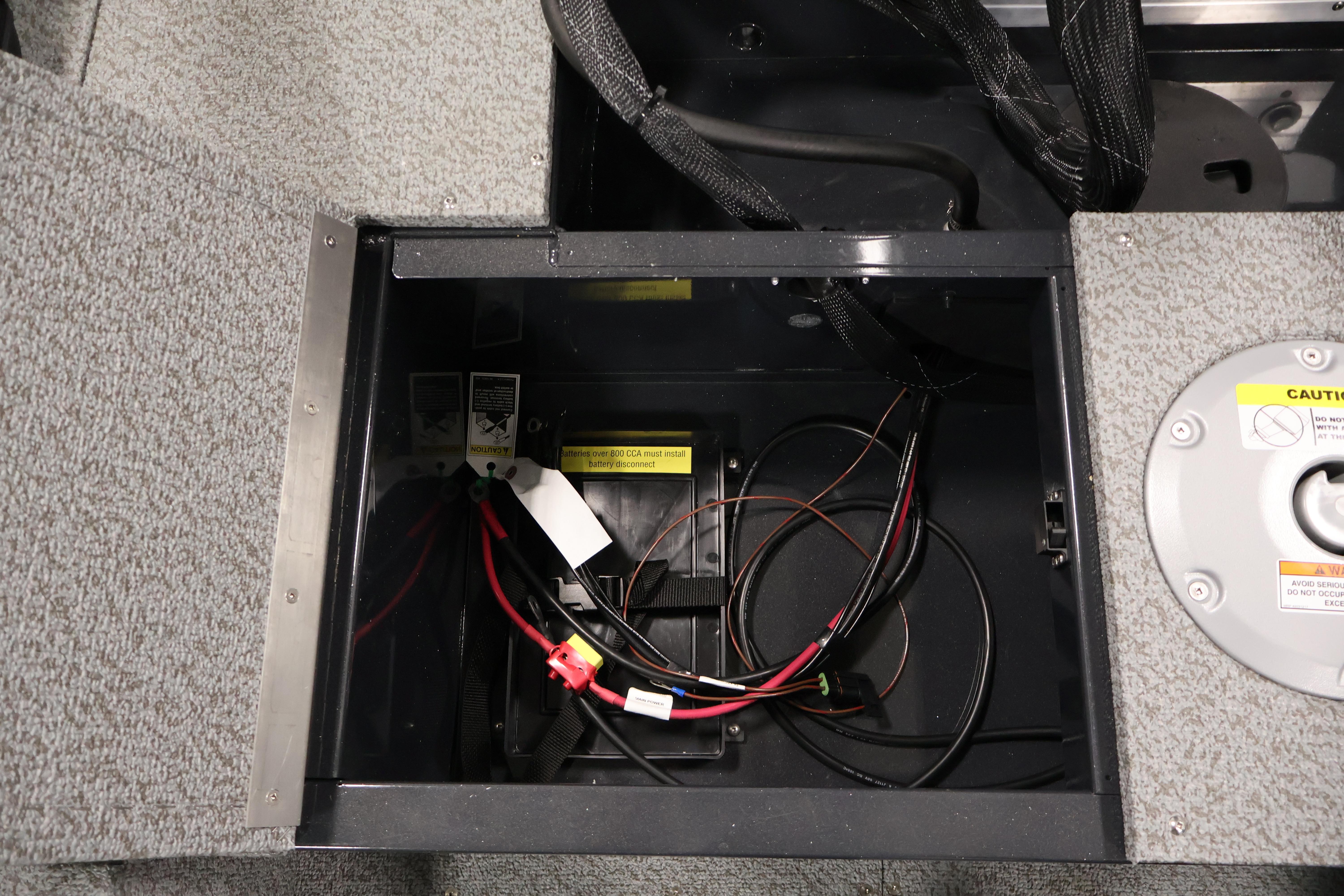 Battery compartment of 2026 Crestliner 1850 Kodiak SC boat with wiring and caution labels.