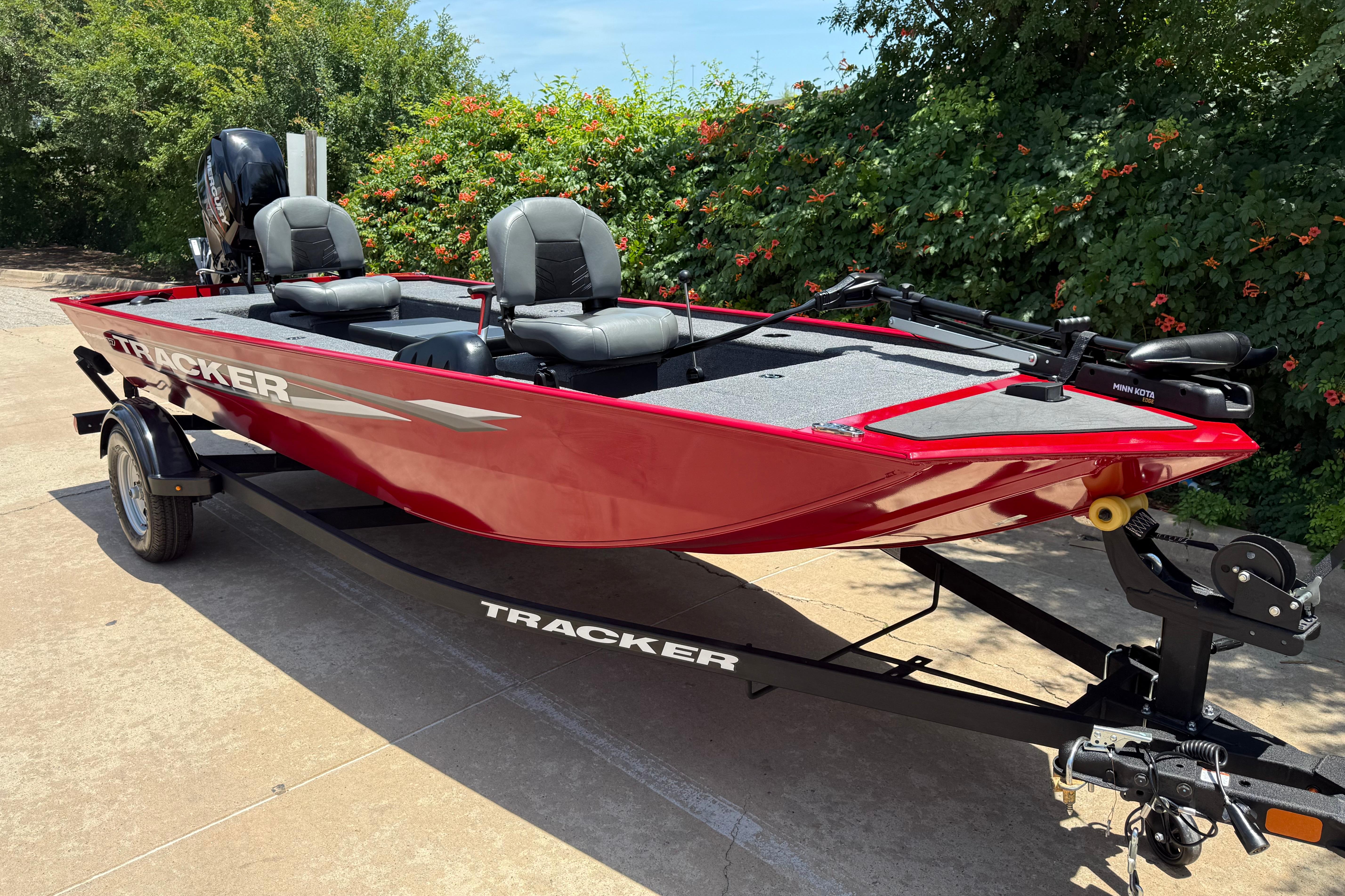 2025 Tracker Panfish 17 boat in vibrant red on a trailer, parked outdoors.