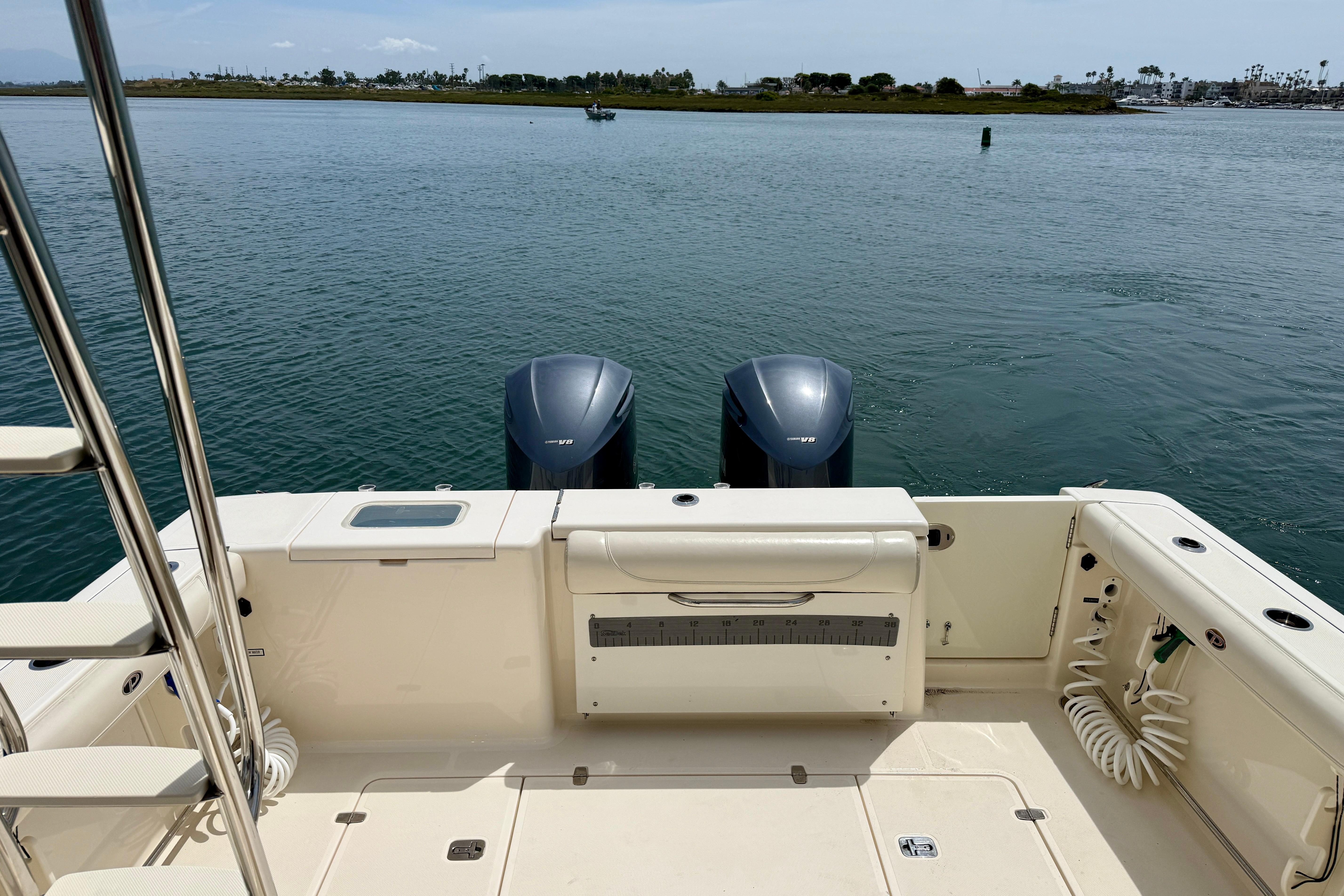 2012 Pursuit OS 345 Offshore boat deck with dual outboard motors on calm water.