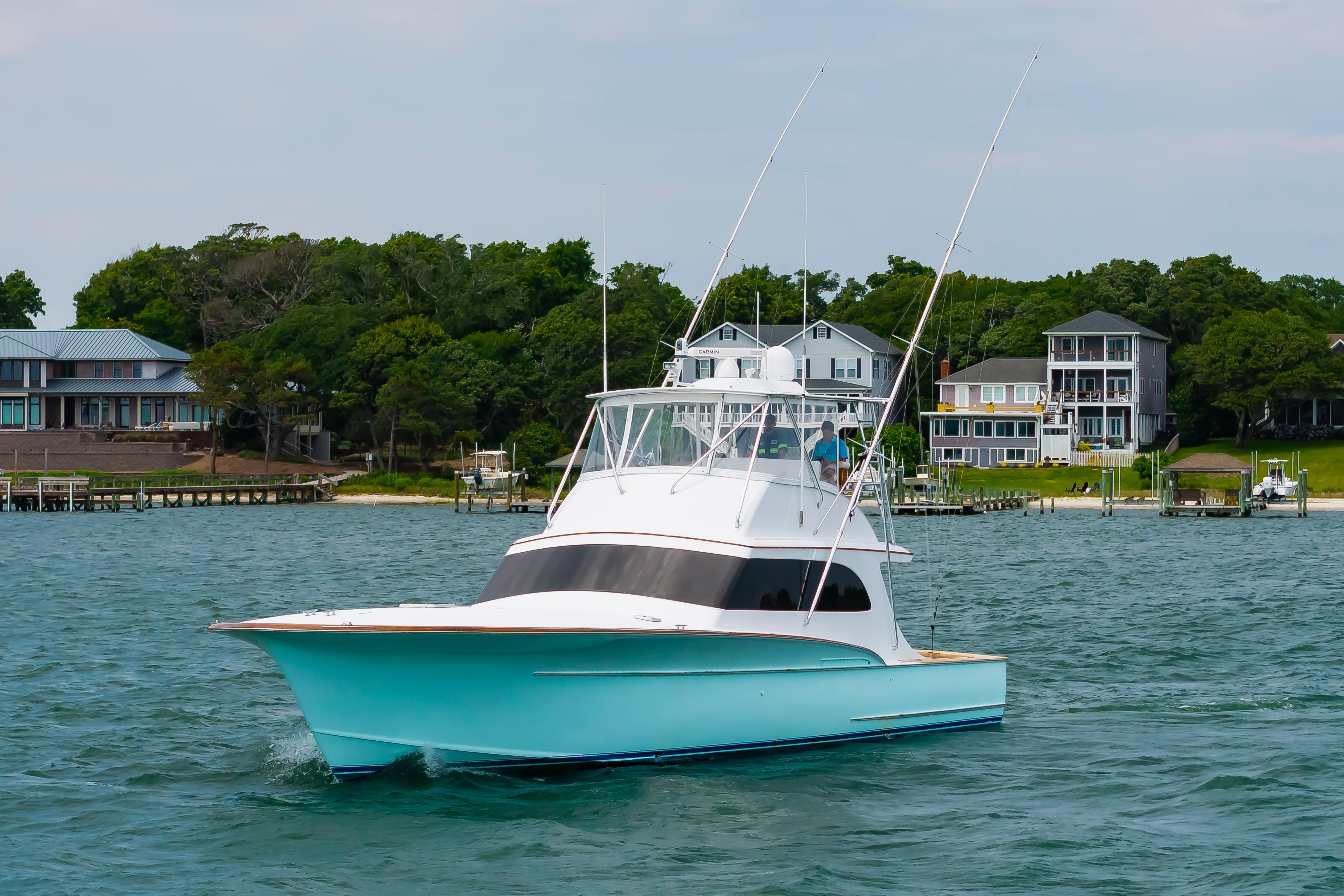 Custom Carolina Scarborough 56 Convertible yacht cruising near waterfront homes, 1993 model.