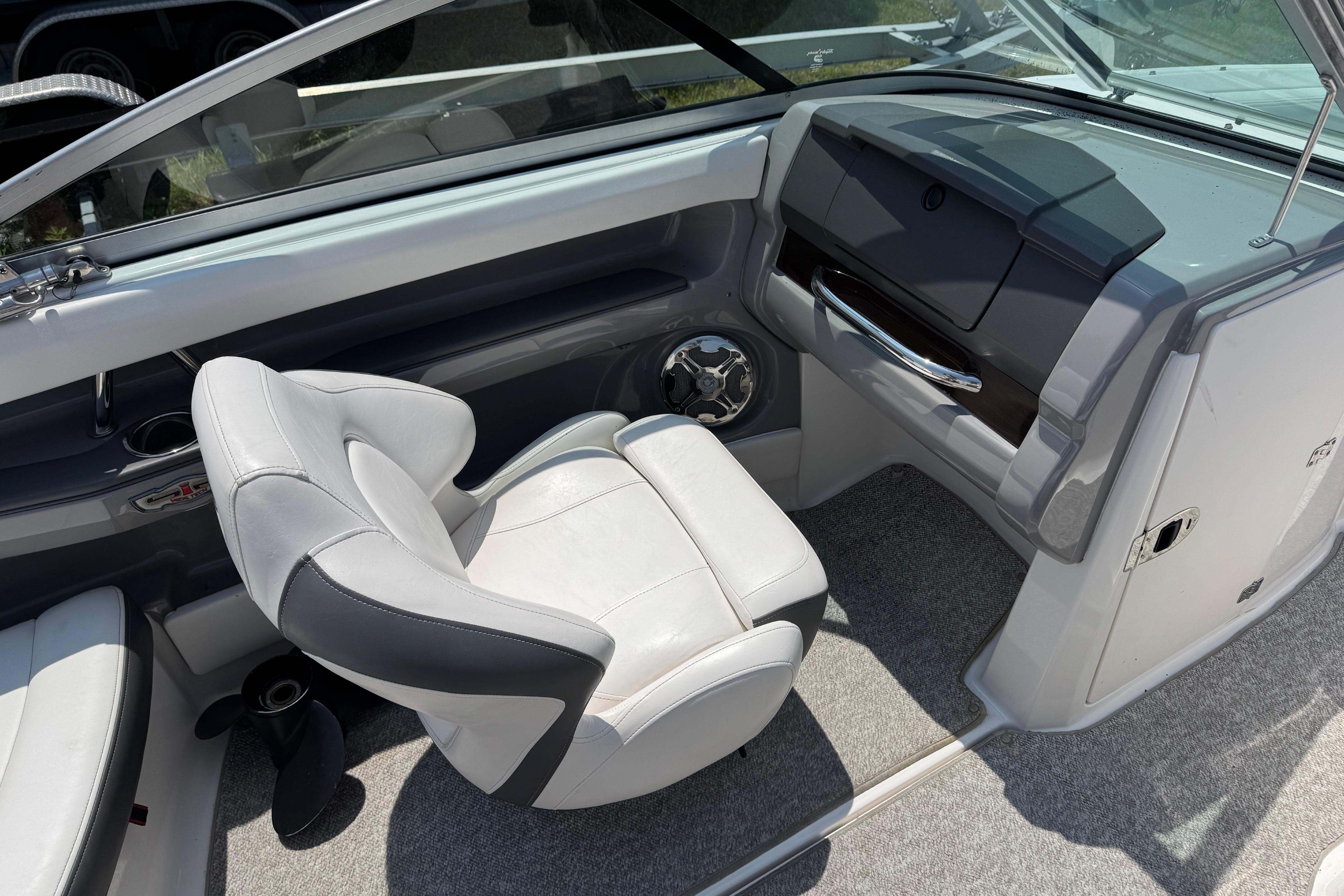 Interior of a 2013 Chaparral 196 SSi boat featuring a sleek captain's chair and dashboard.